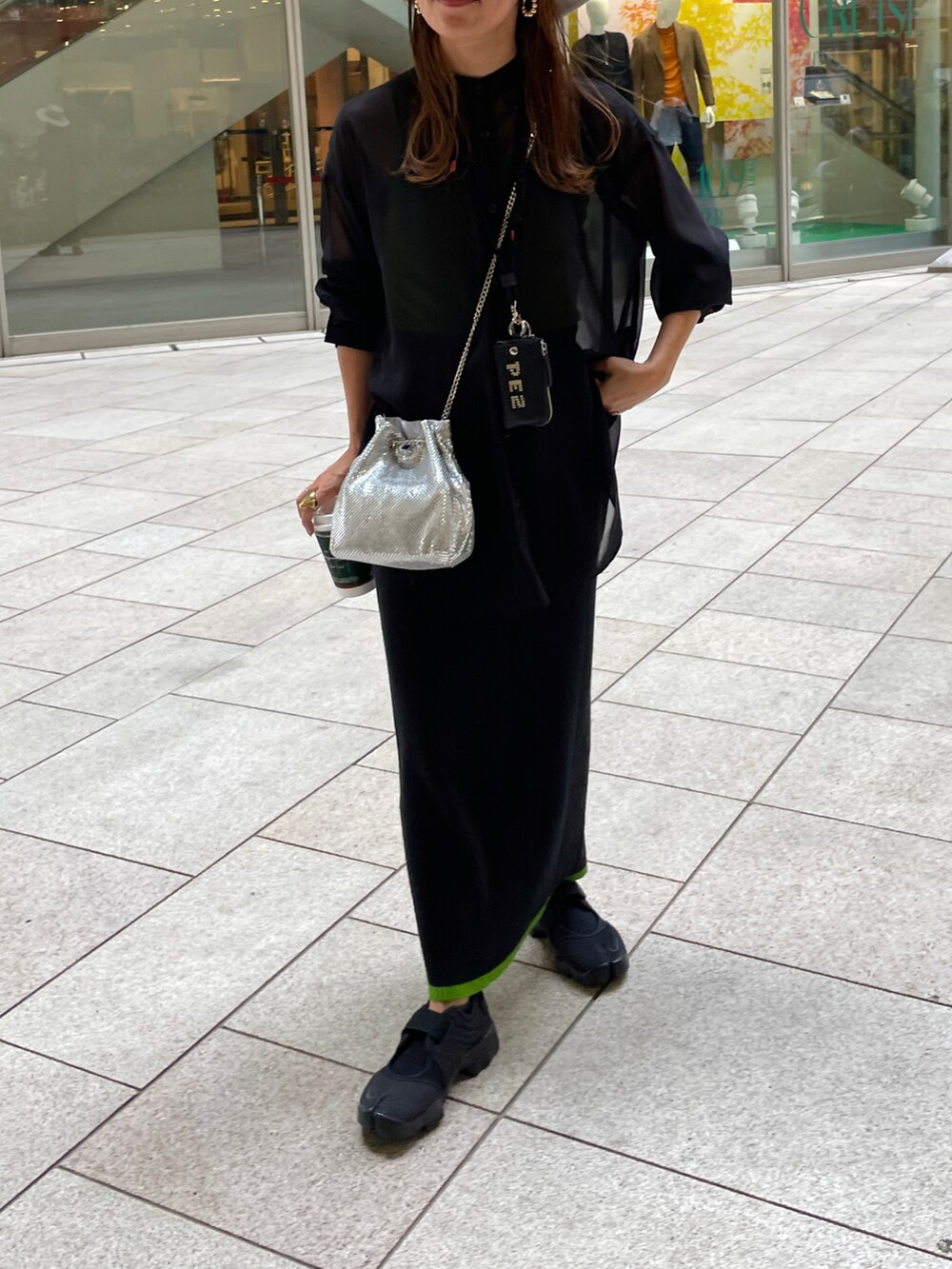 ブラック系のTシャツ/カットソー、シルバー系のショルダーバッグ、ブラック系のスカートを着用したレディースの秋コーディネートの3枚目の写真