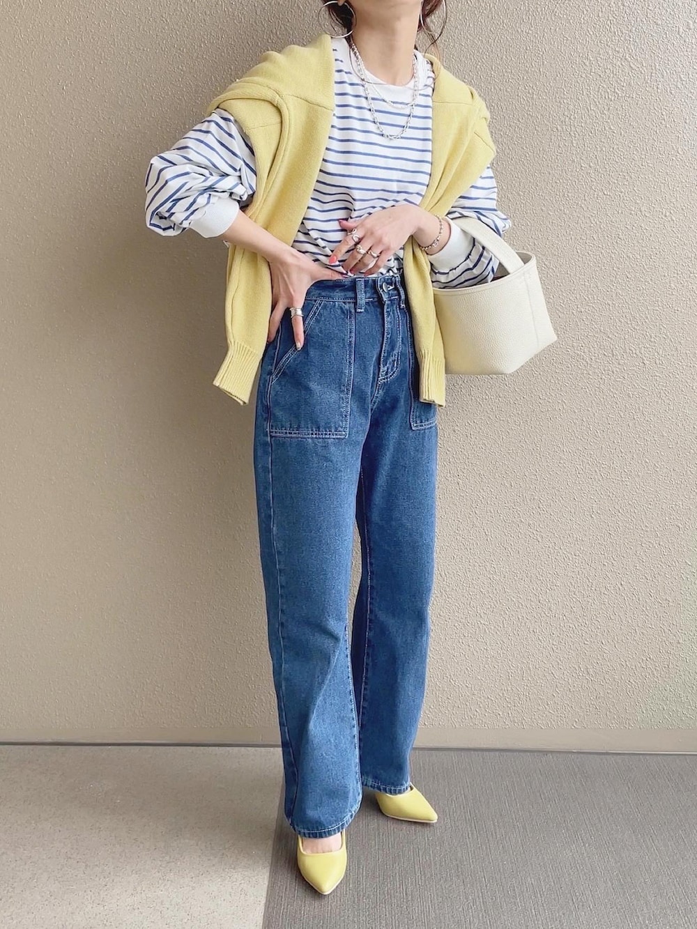 ブルー系のTシャツ/カットソー、ブルー系のデニムパンツ、イエロー系のカーディガン/ボレロを着用したレディースの春コーディネートの2枚目の写真
