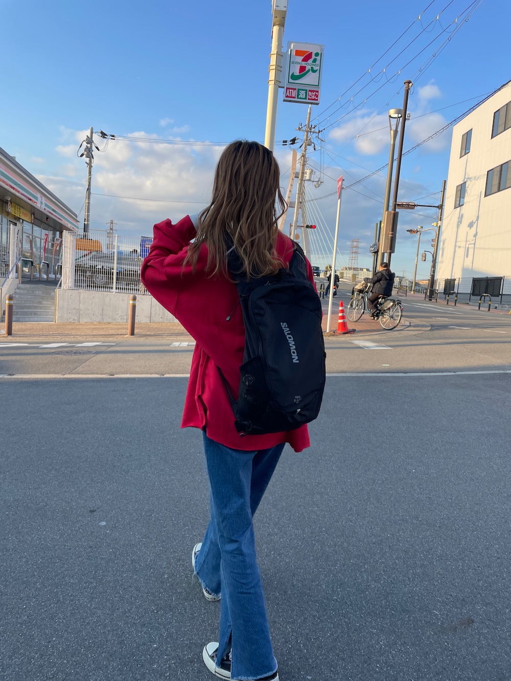 レッド系のスウェット、ブルー系のデニムパンツを着用したレディースの冬コーディネートの2枚目の写真