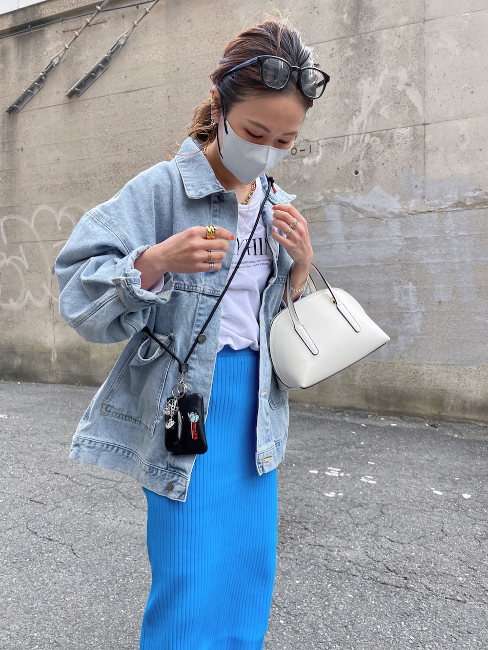 ブルー系のデニムジャケット、ホワイト系のスウェット、ブラック系のカードケースを着用したレディースの春コーディネートの4枚目の写真