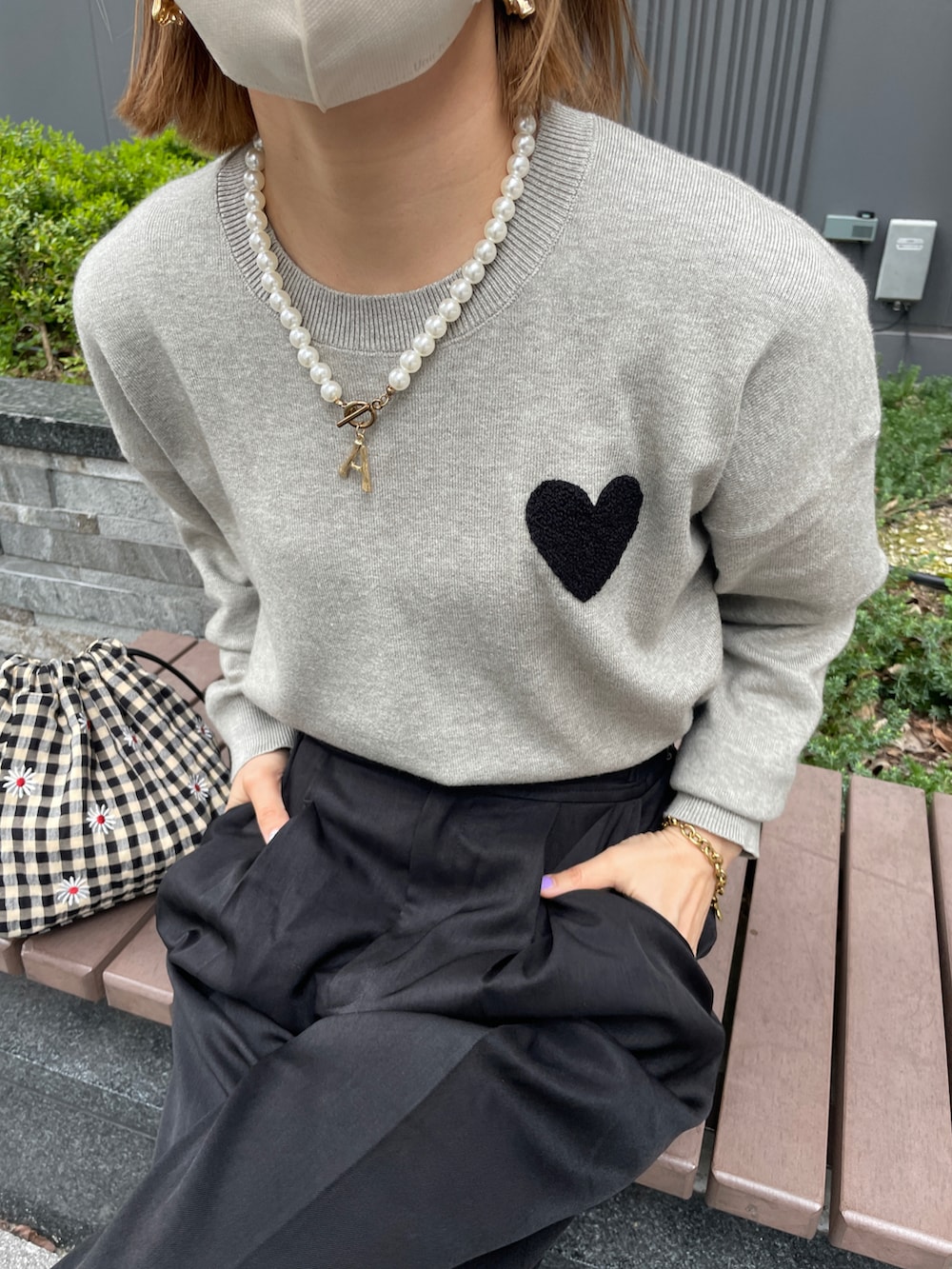 グレー系のニット/セーター、ブラック系のスラックス、その他のハンドバッグを着用したレディースの春コーディネートの4枚目の写真