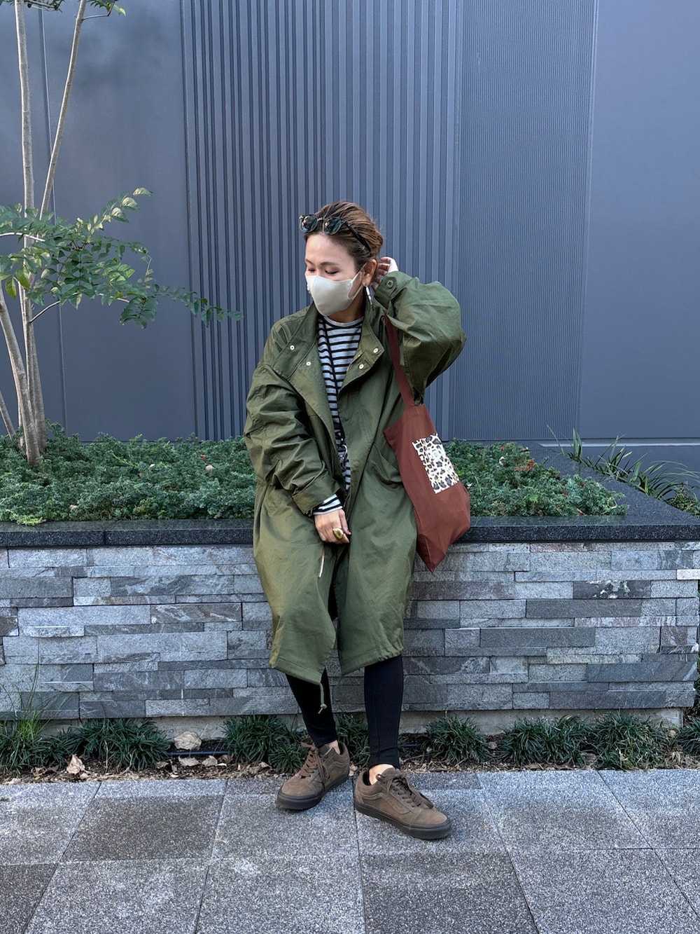 グレー系のTシャツ/カットソー、ブラウン系のトートバッグ、グリーン系のモッズコートを着用したレディースの秋コーディネートの3枚目の写真