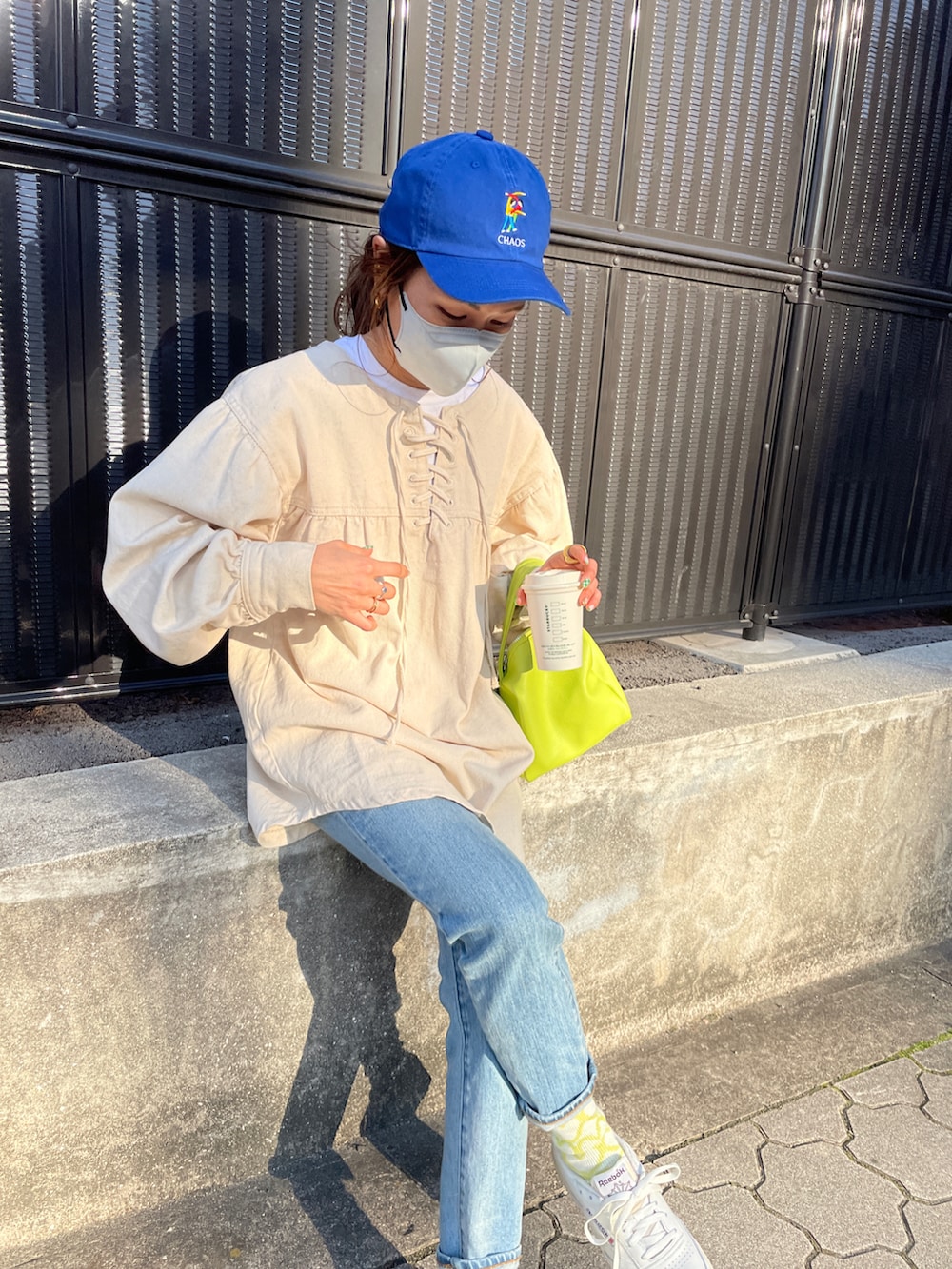 ホワイト系のスニーカー、ブルー系のデニムパンツ、ホワイト系のシャツ/ブラウスを着用したレディースの冬コーディネートの3枚目の写真