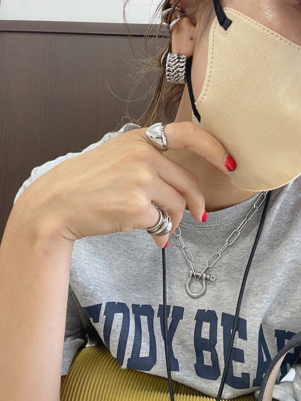 グレー系のTシャツ/カットソー、イエロー系のスカート、ブラック系のサンダルを着用したレディースの夏コーディネートの2枚目の写真