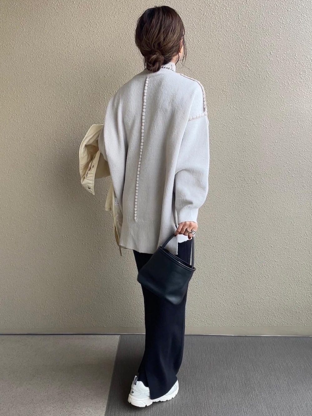 ベージュ系のニット/セーター、ベージュ系のスカート、グリーン系のダウンジャケット/コートを着用したレディースの冬コーディネートの2枚目の写真