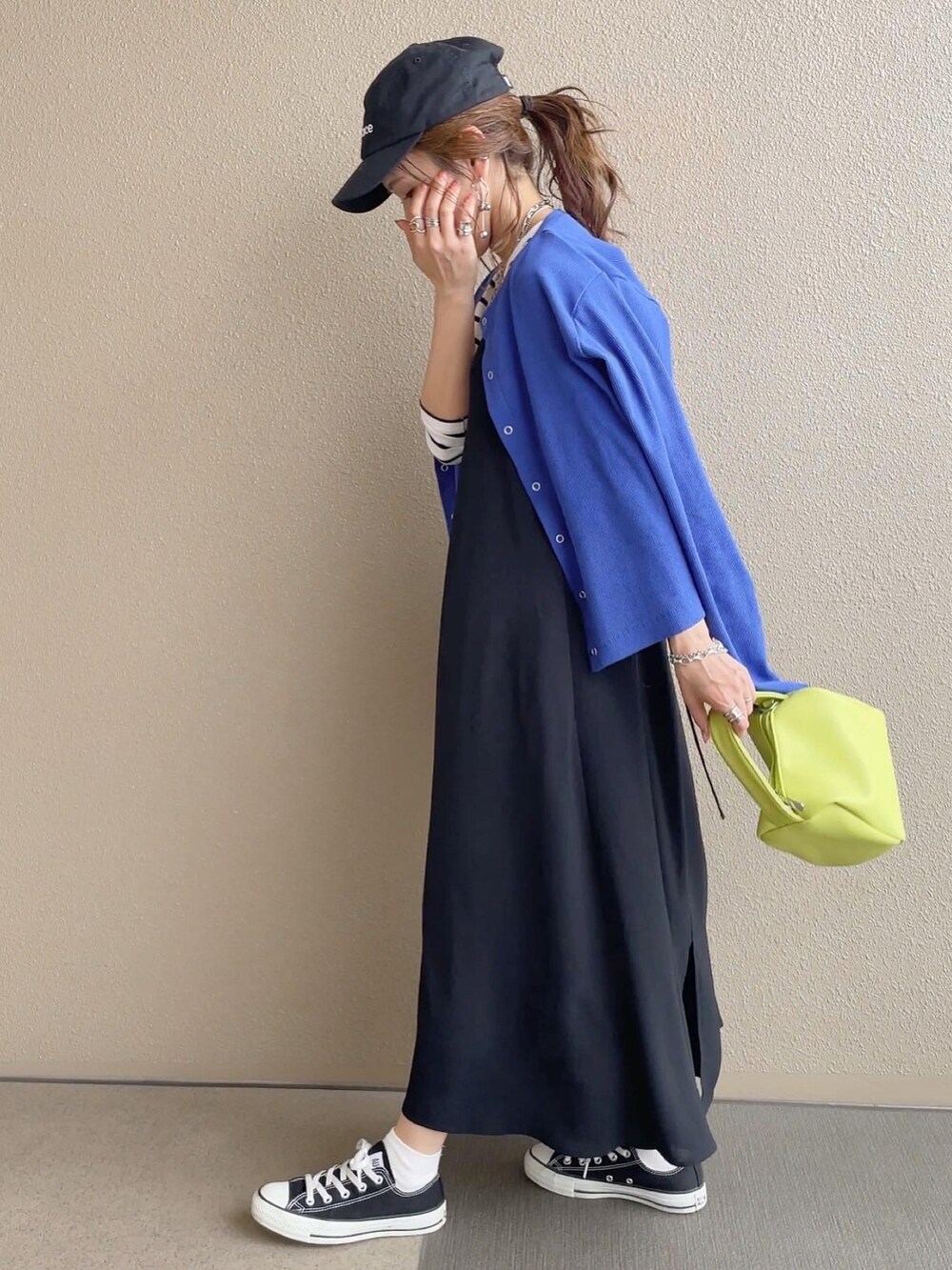 ブルー系のカーディガン/ボレロ、ブルー系のデニムパンツ、ブラック系のワンピースを着用したレディースの春コーディネートの4枚目の写真