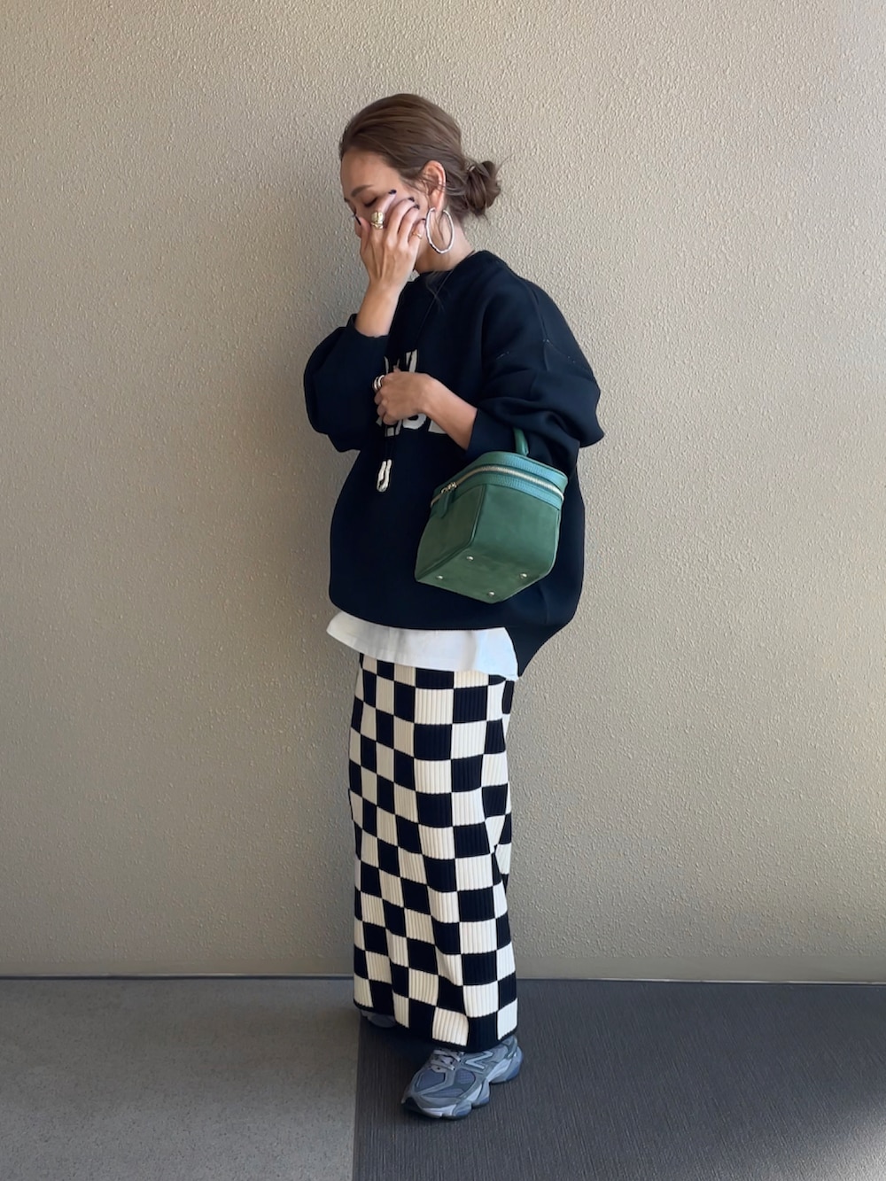 ブラック系のニット/セーター、ホワイト系のスカートを着用したレディースの秋コーディネートの2枚目の写真