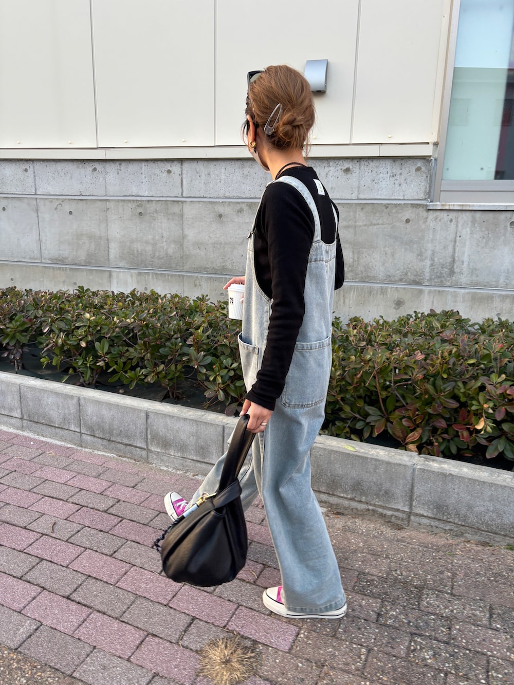 ブルー系のサロペット/オーバーオール、ピンク系のスニーカー、ブラック系のTシャツ/カットソーを着用したレディースの冬コーディネートの3枚目の写真