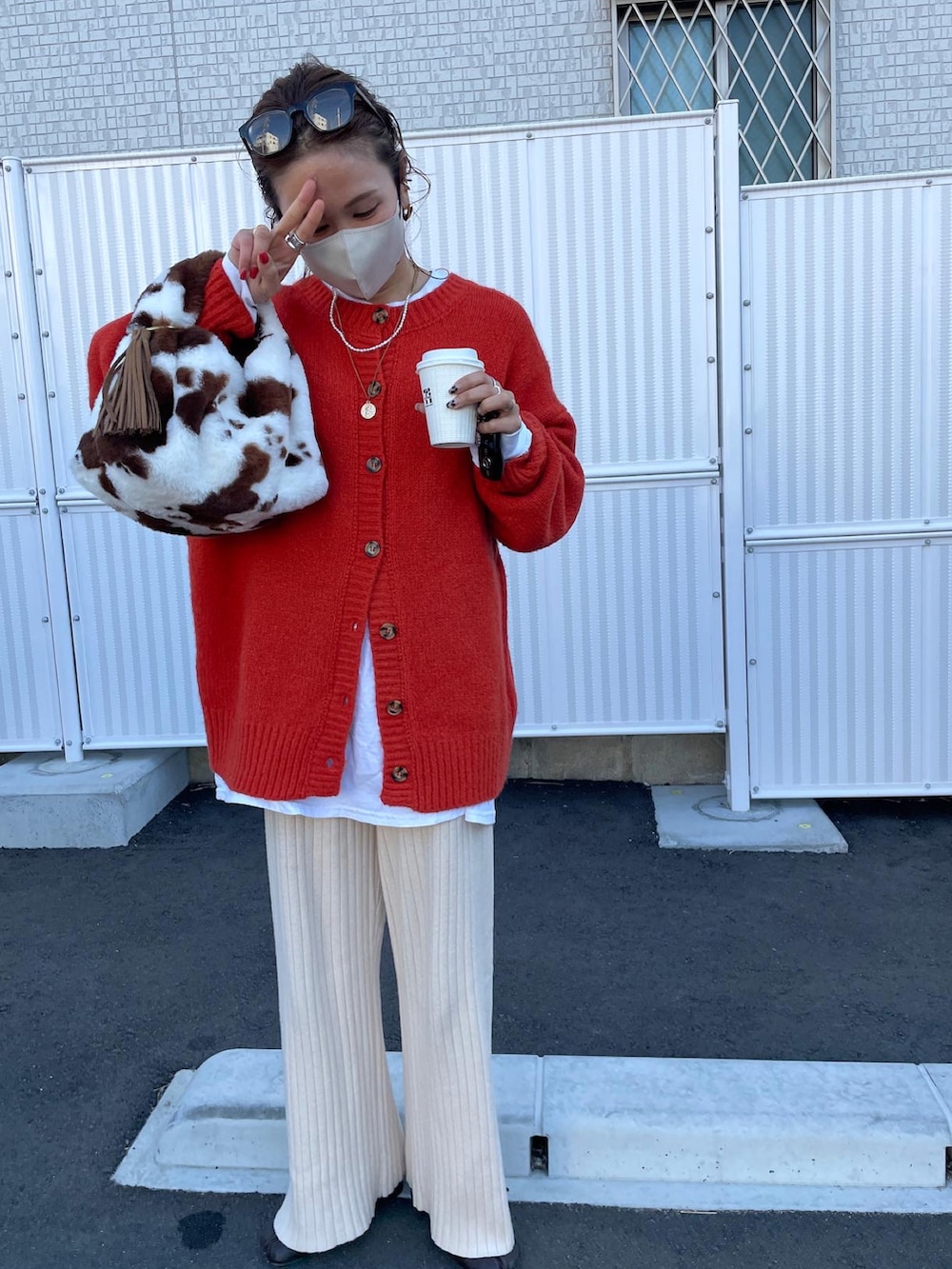 オレンジ系のカーディガン/ボレロ、ホワイト系のTシャツ/カットソー、ベージュ系のその他パンツを着用したレディースの冬コーディネートの4枚目の写真