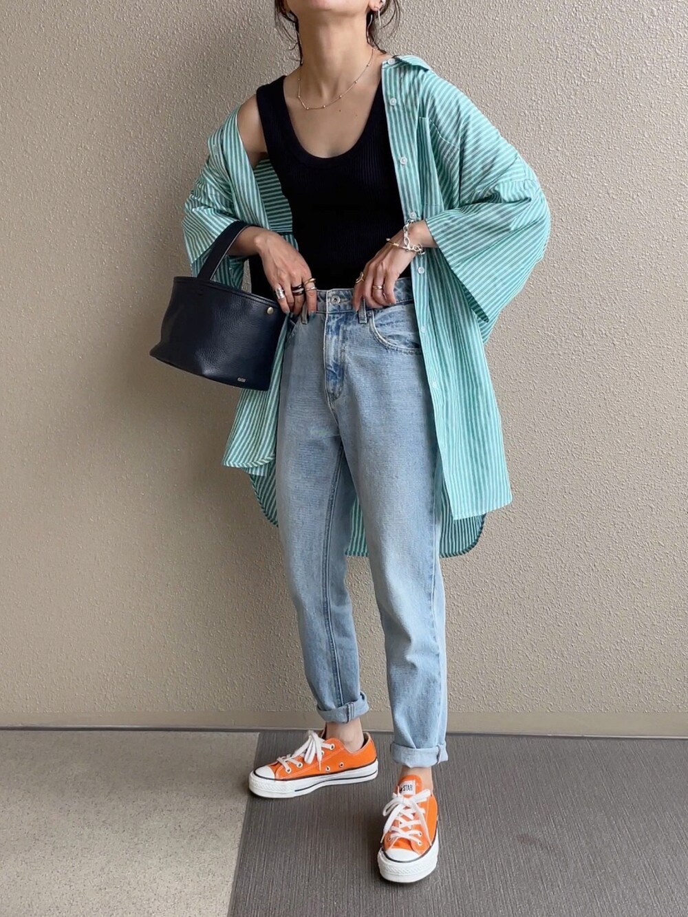 グリーン系のシャツ/ブラウス、オレンジ系のその他パンツ、ブルー系のデニムパンツを着用したレディースの春コーディネートの2枚目の写真