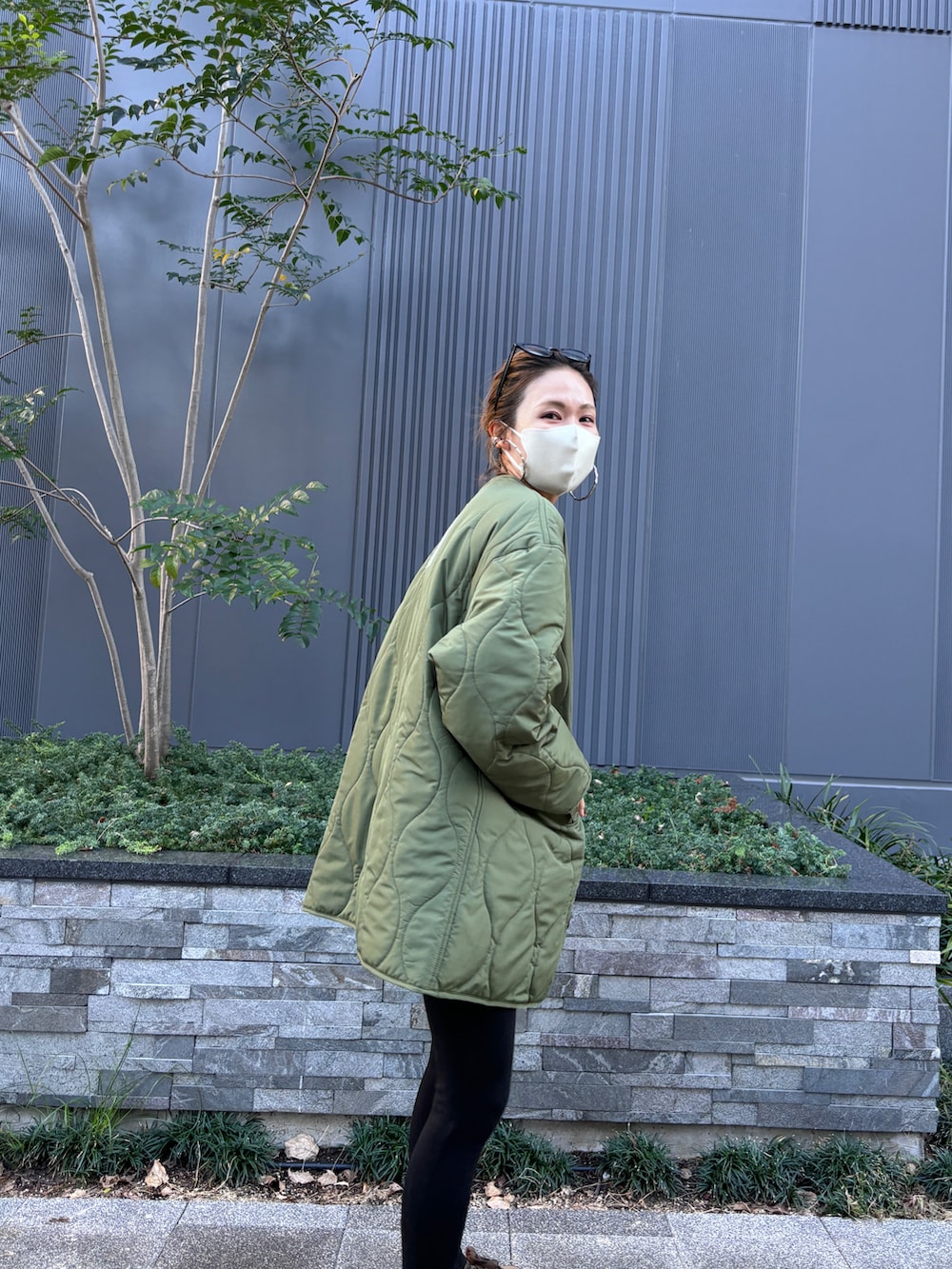 グレー系のTシャツ/カットソー、ブラウン系のトートバッグ、グリーン系のモッズコートを着用したレディースの秋コーディネートの5枚目の写真