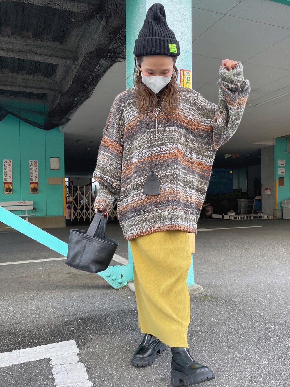 グリーン系のカーディガン/ボレロ、イエロー系のスカートを着用したレディースの秋コーディネートの2枚目の写真