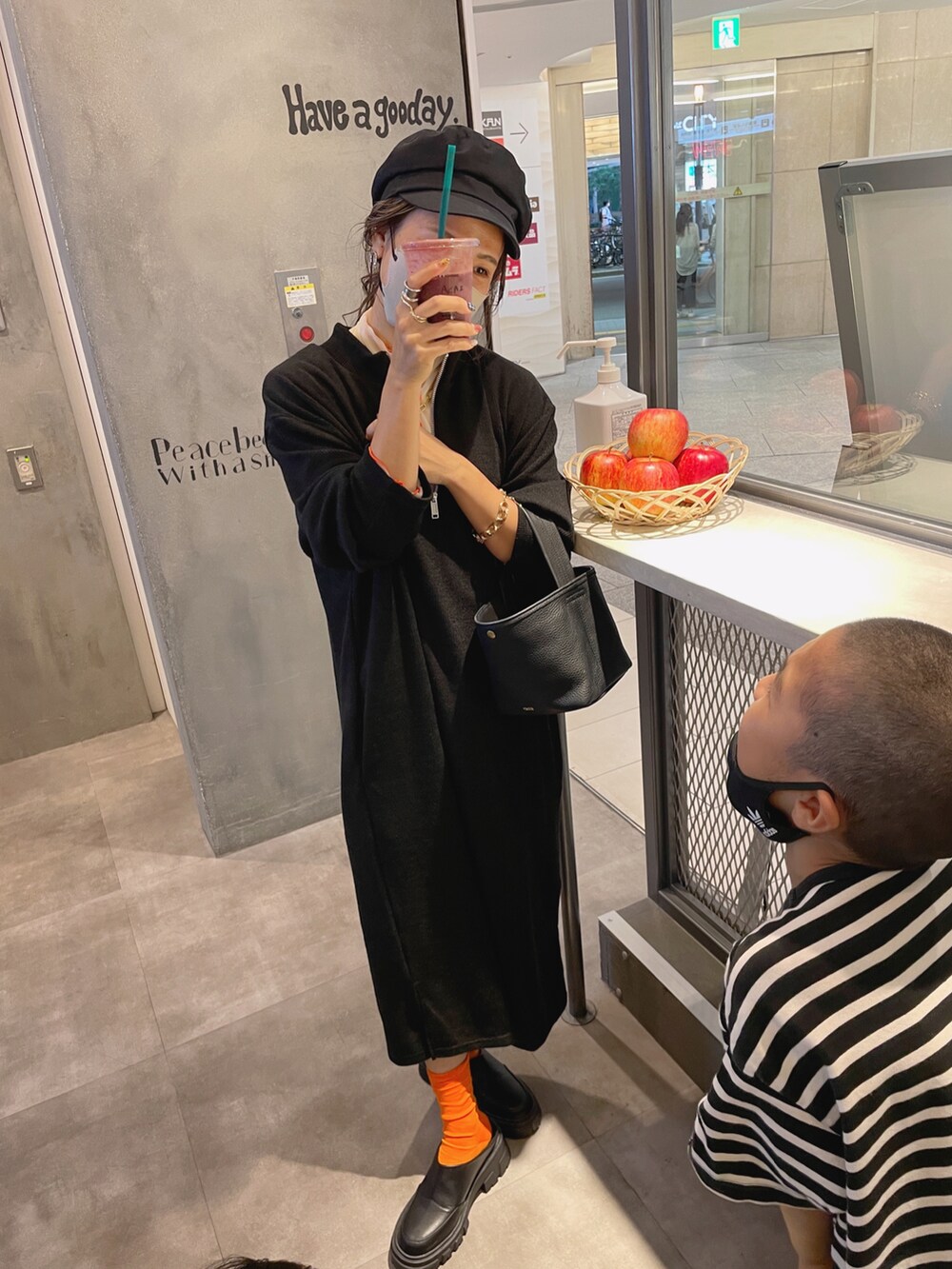 ブラック系のワンピース、ブラック系のスリッポン、ホワイト系のTシャツ/カットソーを着用したレディースの秋コーディネートの2枚目の写真