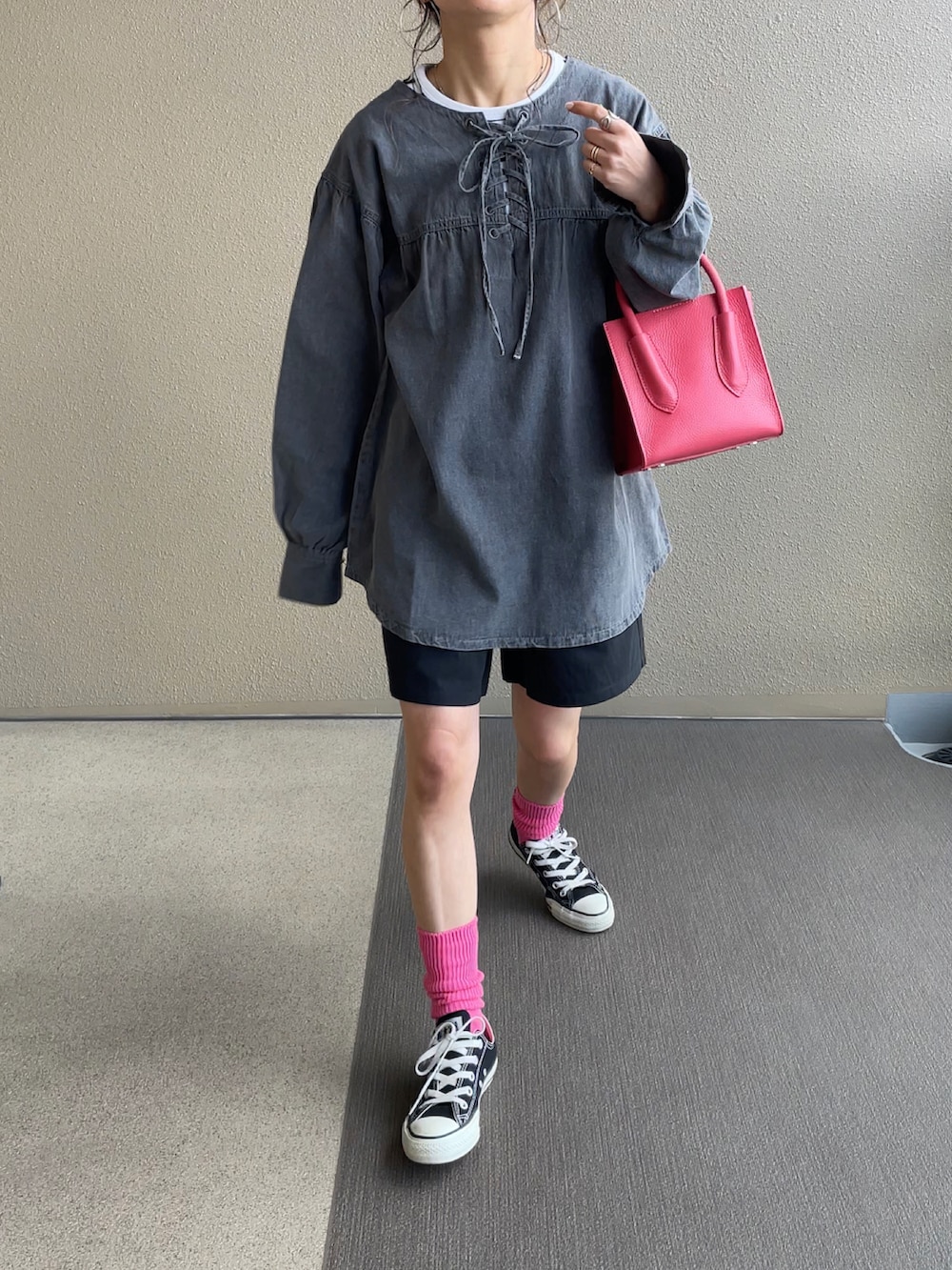 オレンジ系のスラックス、ブラック系のパンプス、ホワイト系のシャツ/ブラウスを着用したレディースの冬コーディネートの2枚目の写真