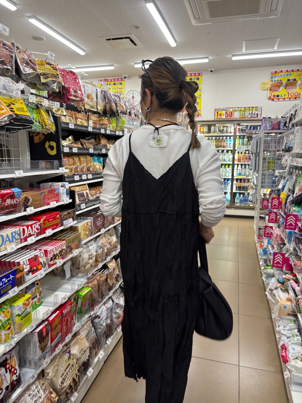 ホワイト系のTシャツ/カットソー、ブラック系のワンピース/ドレス、ホワイト系のサンダルを着用したレディースの春コーディネートの3枚目の写真