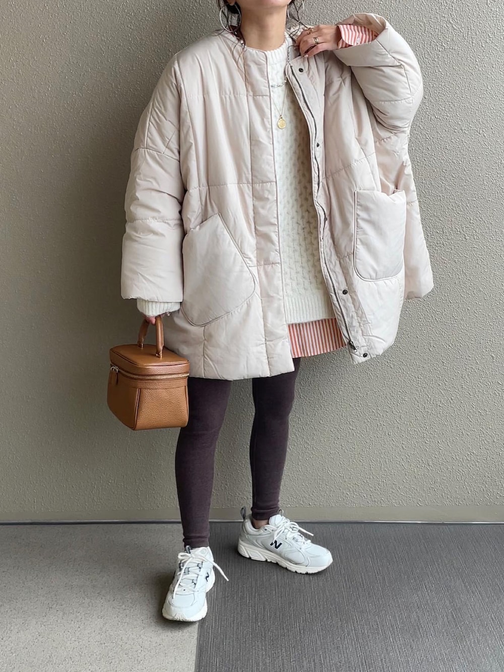 グリーン系のミリタリージャケット、ホワイト系のニット/セーター、ブルー系のニット/セーターを着用したレディースの冬コーディネートの2枚目の写真