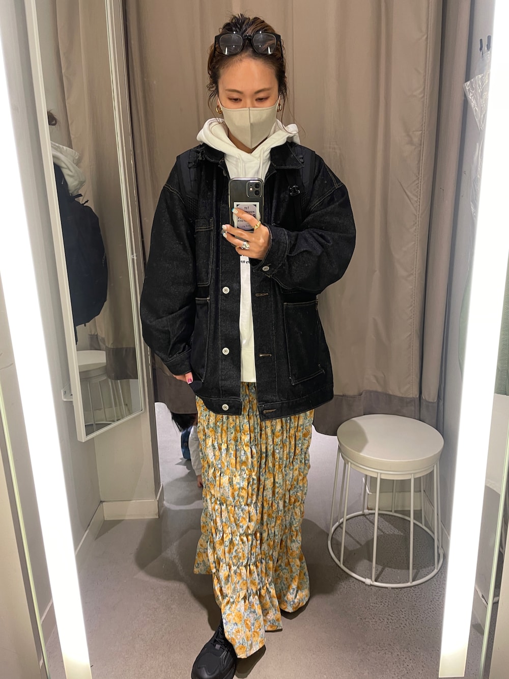 ホワイト系のパーカー、ブラック系のデニムジャケット、イエロー系のスカートを着用したレディースの冬コーディネートの4枚目の写真