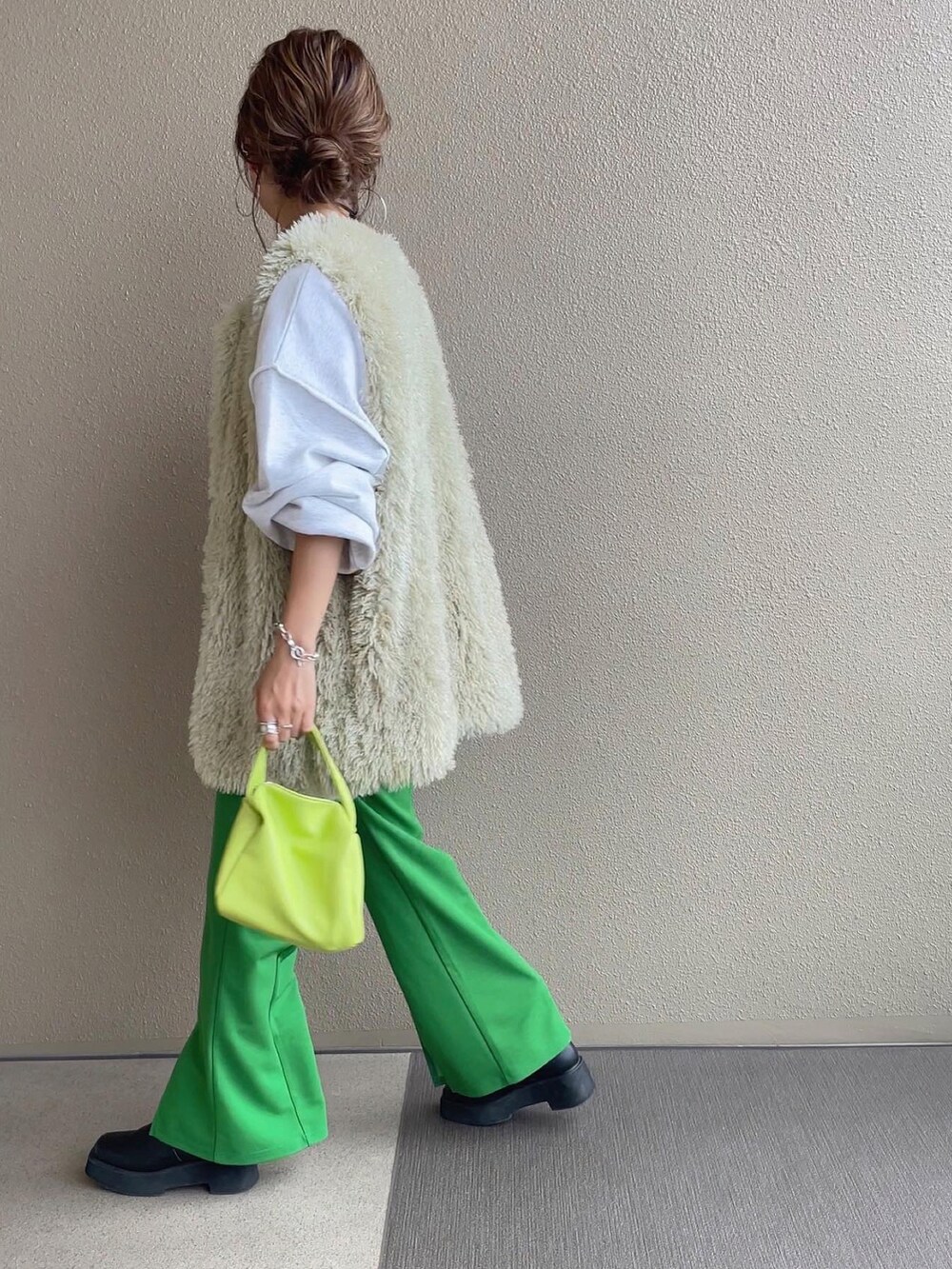 ベージュ系のスウェット、グリーン系のベスト、グリーン系のスラックスを着用したレディースの秋コーディネートの4枚目の写真