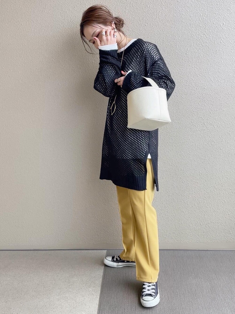 ブラック系のニット/セーター、イエロー系のその他パンツ、ホワイト系のTシャツ/カットソーを着用したレディースの冬コーディネートの4枚目の写真