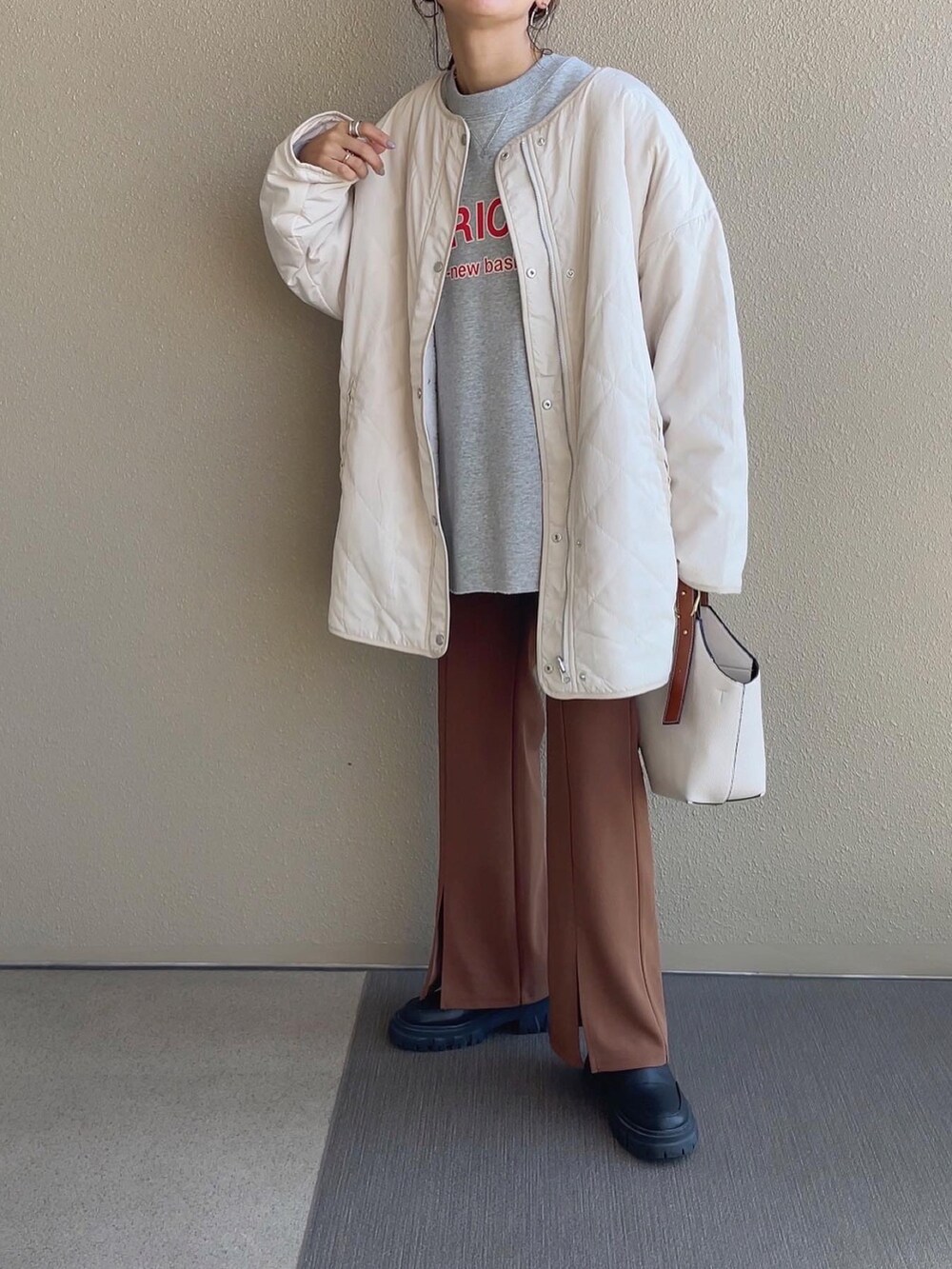 ホワイト系のノーカラージャケット、ピンク系のスウェット、ブラック系のスカートを着用したレディースの秋コーディネートの2枚目の写真