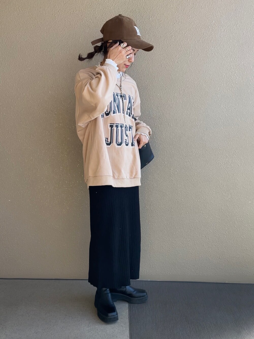 ベージュ系のスウェット、ブラウン系のその他アウター、ブラック系のブーツを着用したレディースの秋コーディネートの2枚目の写真