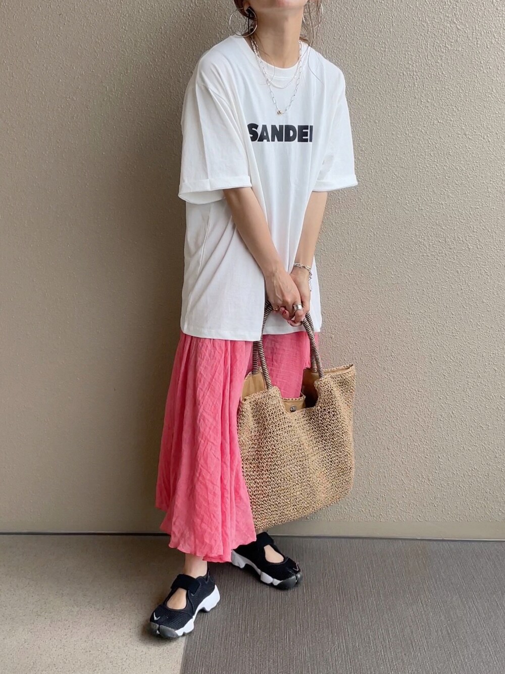 オレンジ系のスカート、ブルー系のシャツ/ブラウス、ブラック系のニット/セーターを着用したレディースの春コーディネートの2枚目の写真