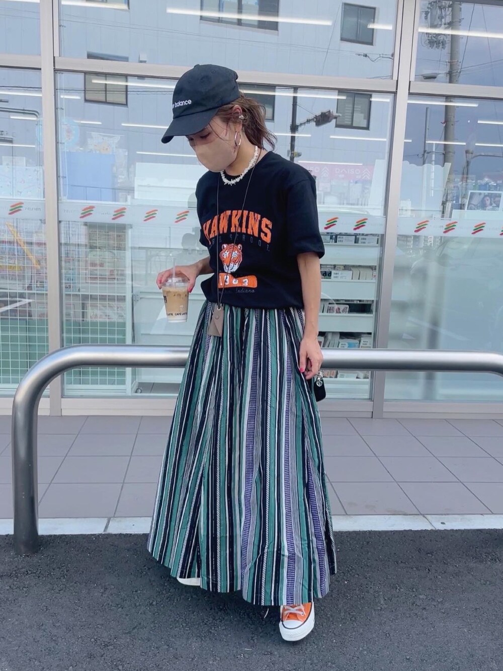 グリーン系のスカート、ホワイト系のトートバッグ、オレンジ系のスニーカーを着用したレディースの夏コーディネートの4枚目の写真