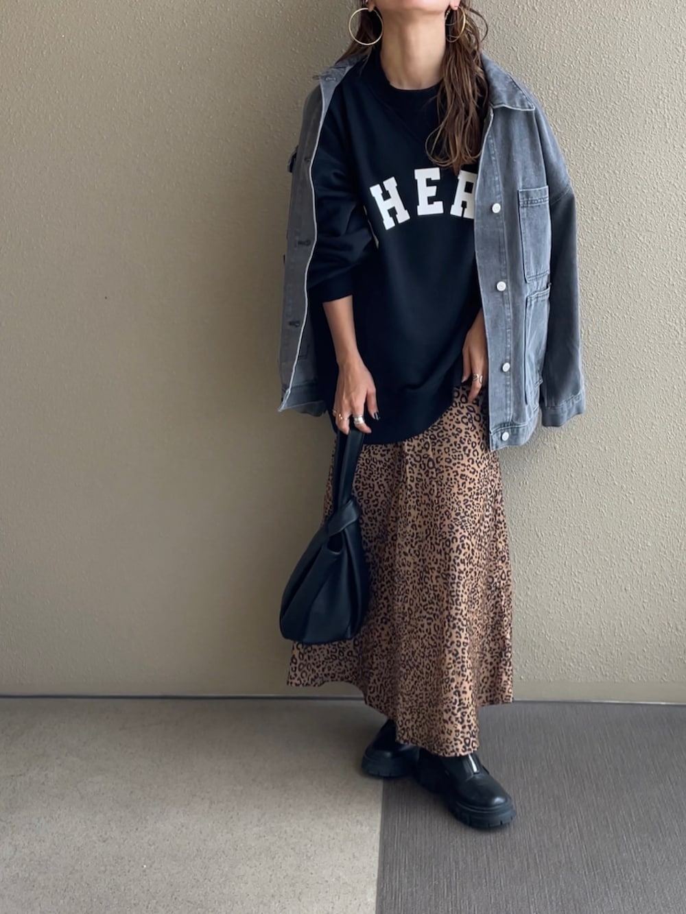 ブラック系のスウェット、ベージュ系のスカート、ブラック系のその他パンツを着用したレディースの秋コーディネートの4枚目の写真