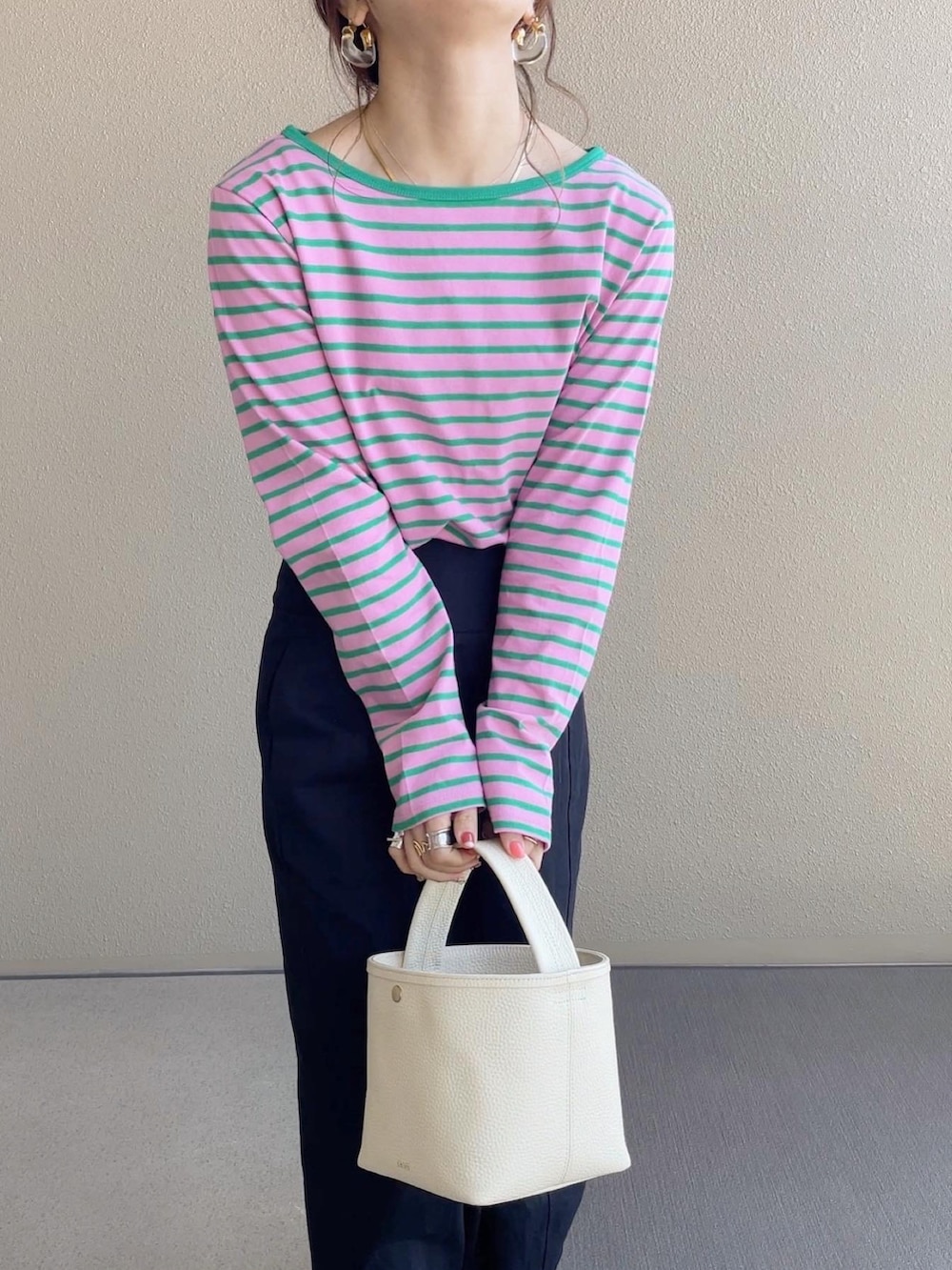 ピンク系のTシャツ/カットソー、ブラック系のスカート、ブルー系のデニムジャケットを着用したレディースの春コーディネートの4枚目の写真