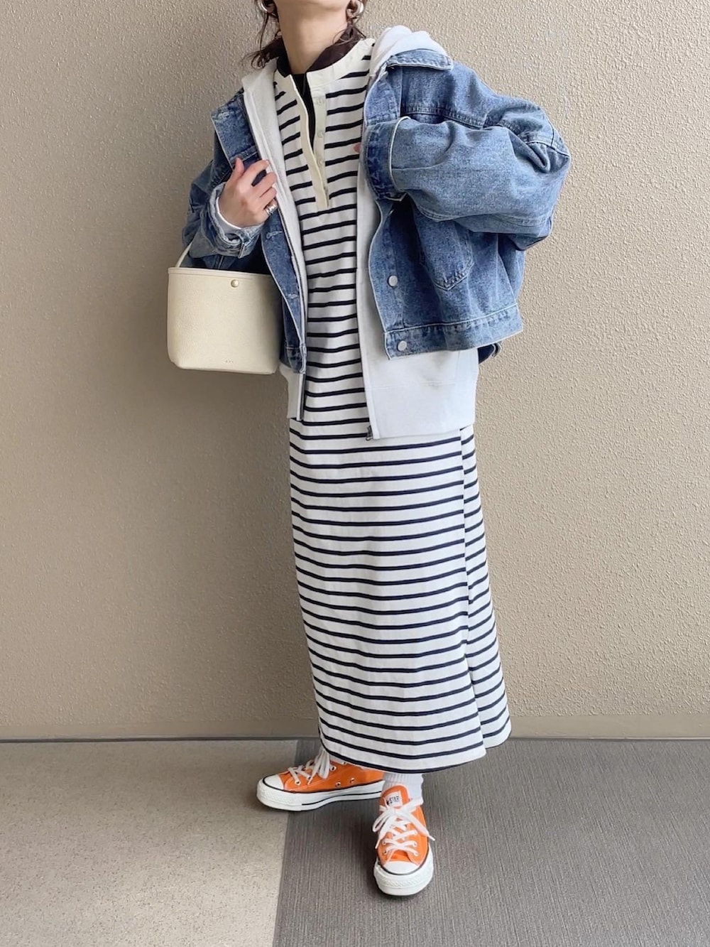 ホワイト系のワンピース/ドレス、ブルー系のデニムジャケット、オレンジ系のスニーカーを着用したレディースの冬コーディネートの4枚目の写真