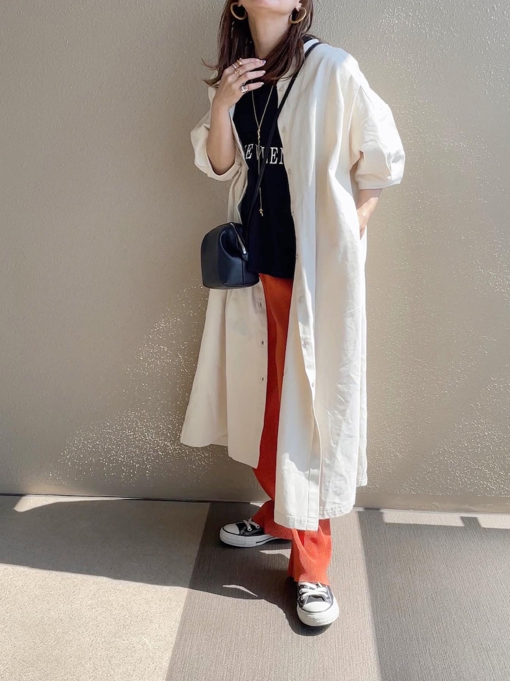 ブラック系のTシャツ/カットソー、オレンジ系のその他パンツ、ホワイト系のワンピースを着用したレディースの春コーディネートの5枚目の写真