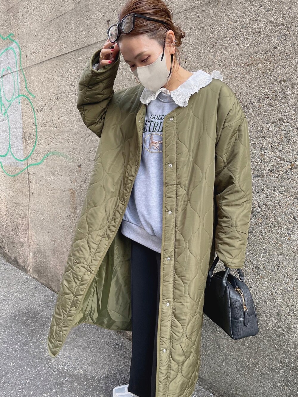 グレー系のスウェット、グリーン系のノーカラーコート、ブラック系のスラックスを着用したレディースの冬コーディネートの5枚目の写真