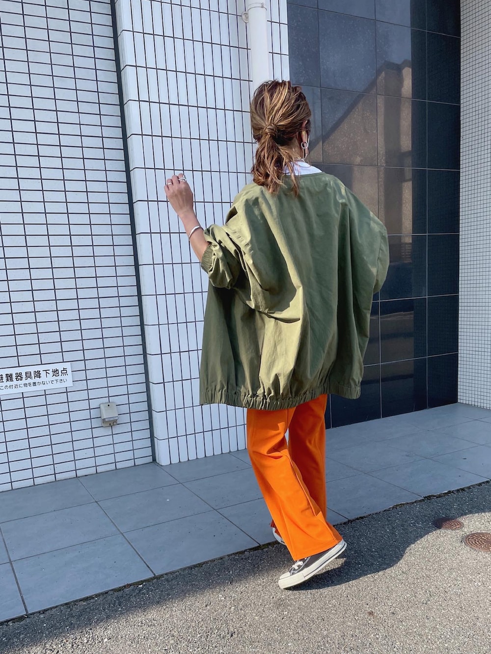 オレンジ系のスラックス、グリーン系のノーカラージャケットを着用したレディースの秋コーディネートの5枚目の写真