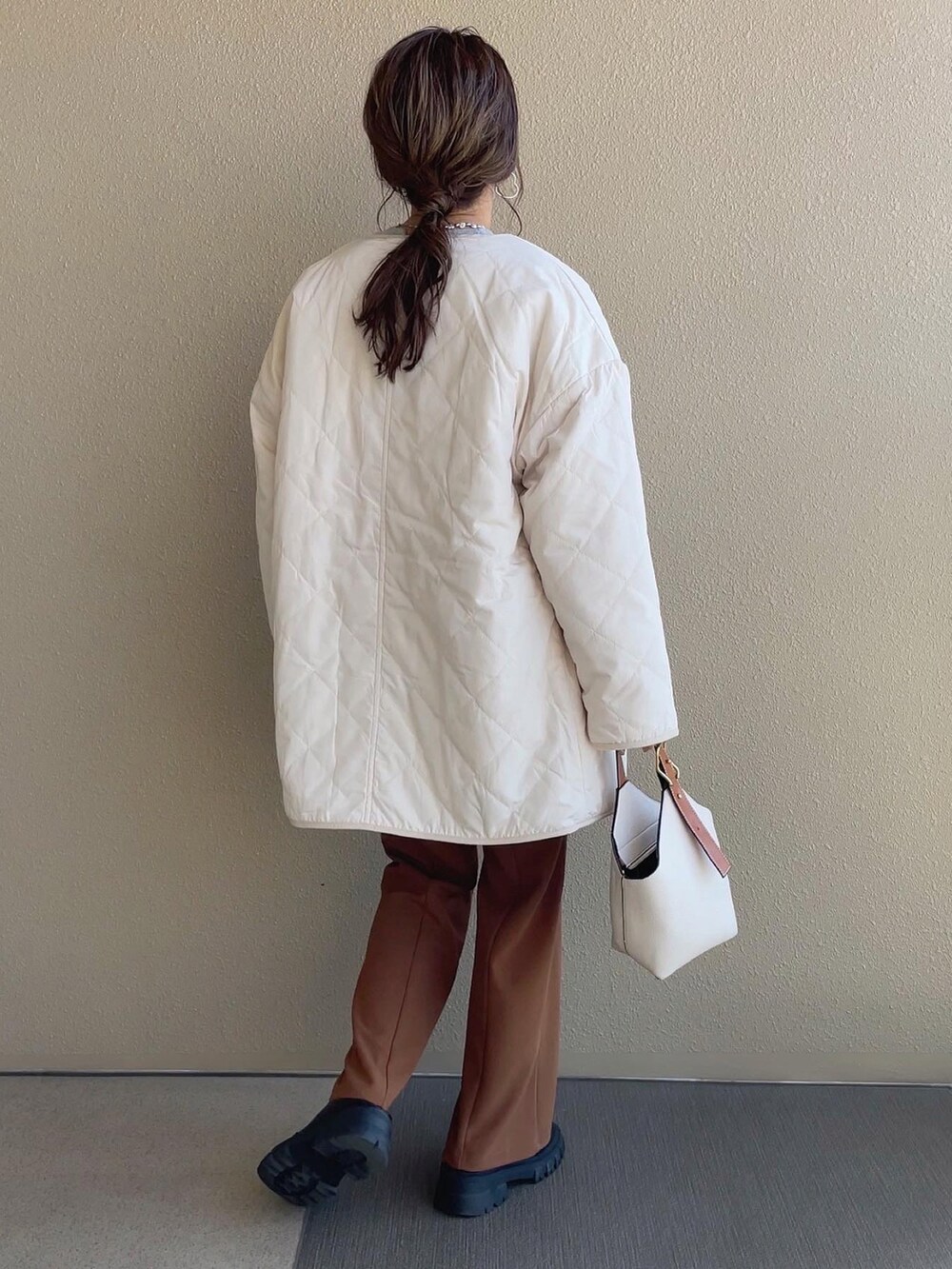 ホワイト系のノーカラージャケット、ピンク系のスウェット、ブラック系のスカートを着用したレディースの秋コーディネートの4枚目の写真