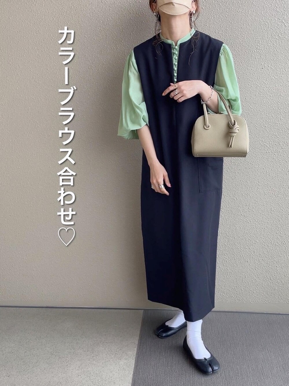 ブラック系のジャンパースカート、ピンク系のシャツ/ブラウス、グレー系のTシャツ/カットソーを着用したレディースの春コーディネートの2枚目の写真