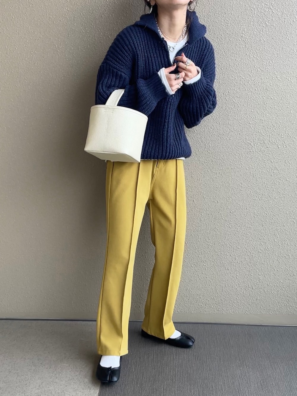 ホワイト系のノーカラージャケット、ブルー系のニット/セーター、イエロー系のその他パンツを着用したレディースの冬コーディネートの2枚目の写真