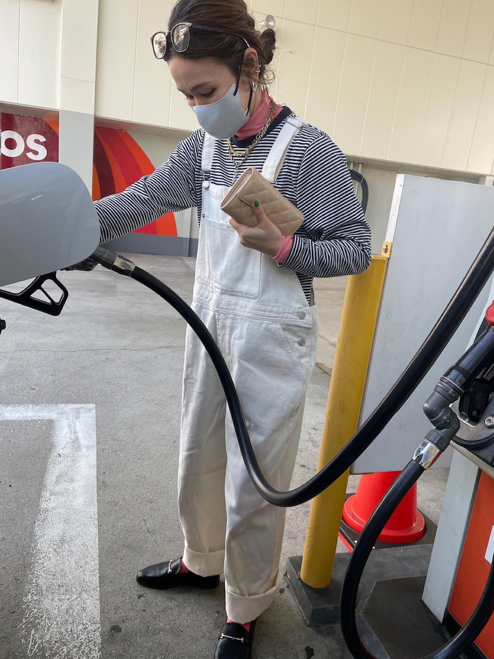 ブルー系のミリタリージャケット、ホワイト系のサロペット/オーバーオール、ホワイト系のハンドバッグを着用したレディースの春コーディネートの4枚目の写真