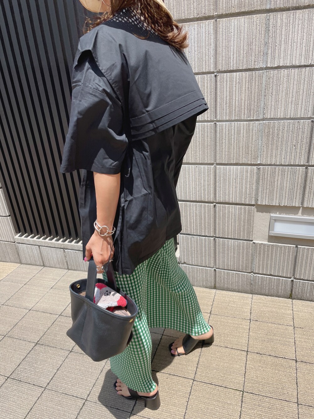 ブラック系のシャツ/ブラウス、グリーン系のスカート、ベージュ系のハットを着用したレディースの夏コーディネートの4枚目の写真