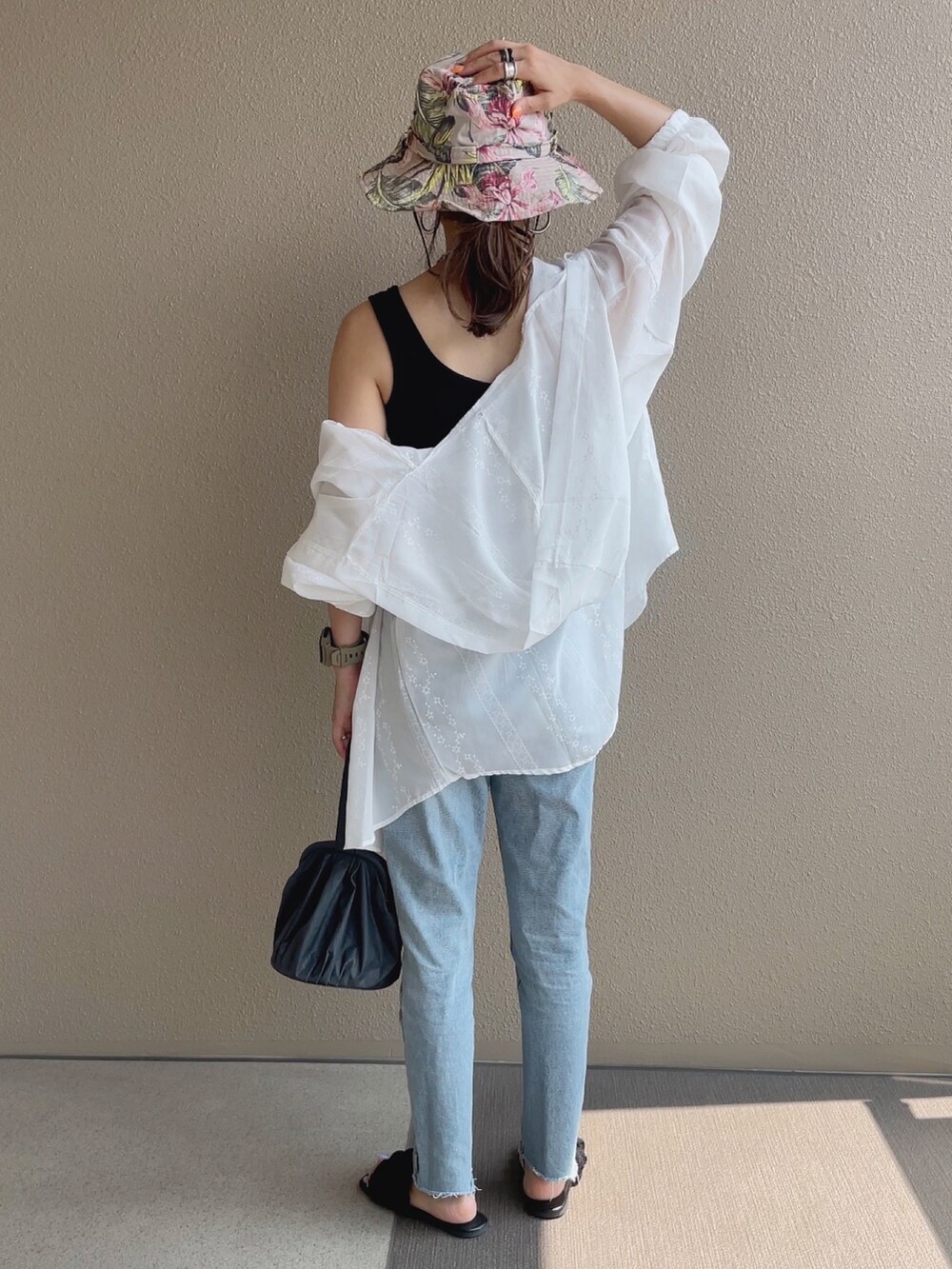 ブルー系のデニムパンツ、ブラック系のタンクトップを着用したレディースの夏コーディネートの2枚目の写真