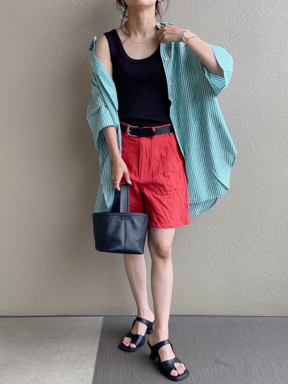 グリーン系のシャツ/ブラウス、オレンジ系のその他パンツ、ブルー系のデニムパンツを着用したレディースの春コーディネートの3枚目の写真