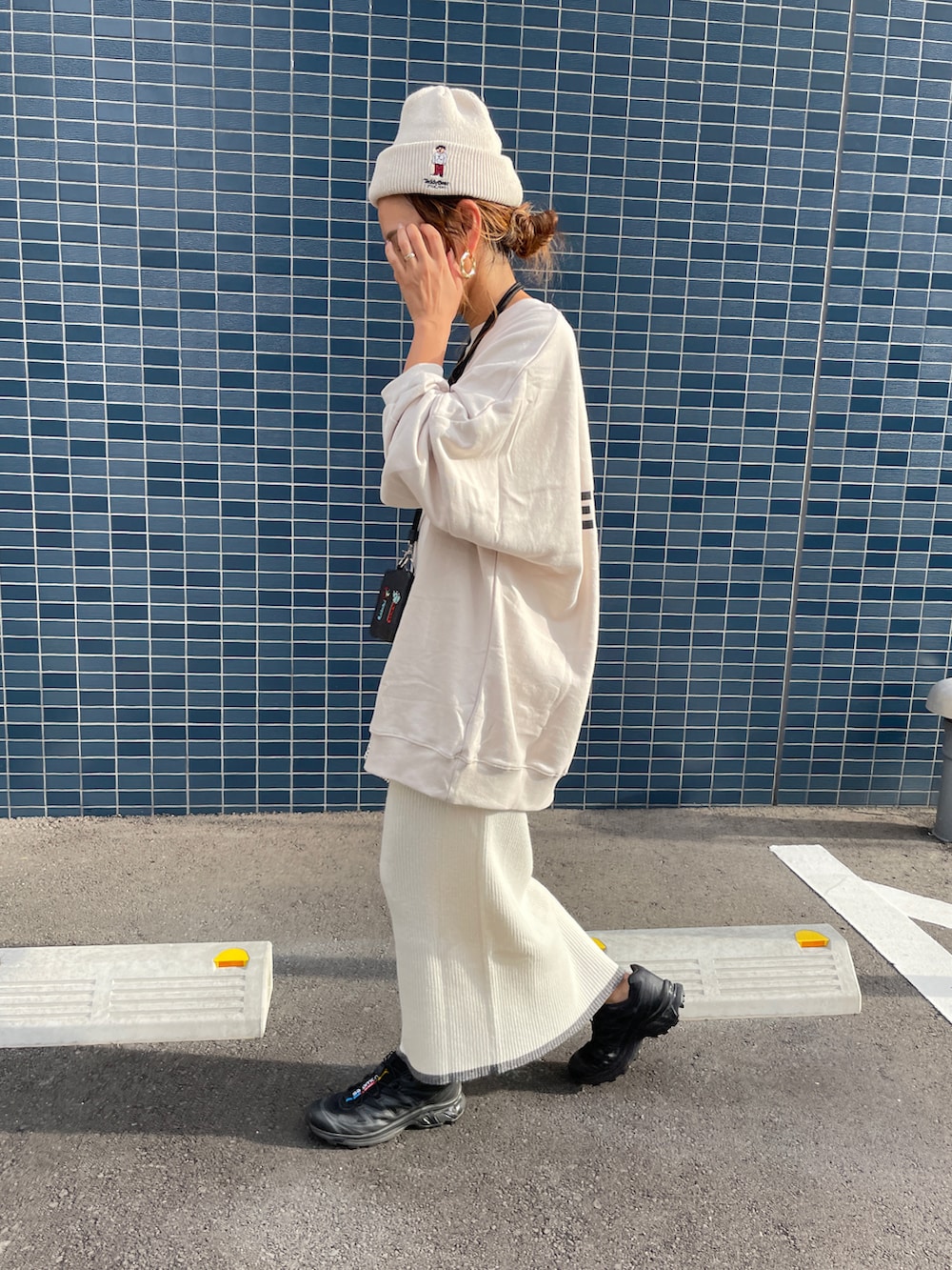 ホワイト系のスカート、ホワイト系のスウェット、シルバー系のバッグを着用したレディースの秋コーディネートの3枚目の写真