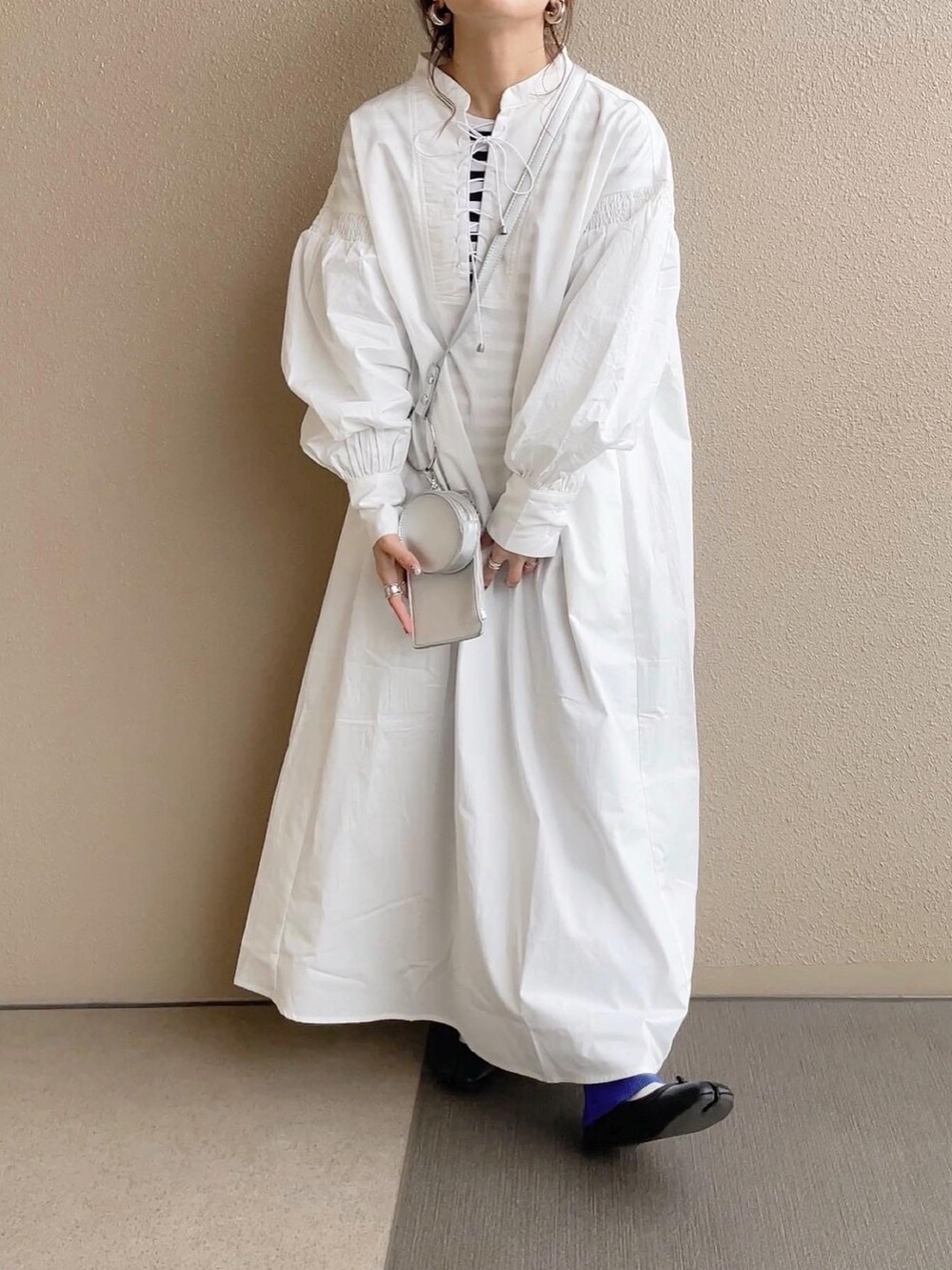 ホワイト系のワンピース、ブルー系のその他パンツ、ホワイト系のショルダーバッグを着用したレディースの冬コーディネートの2枚目の写真