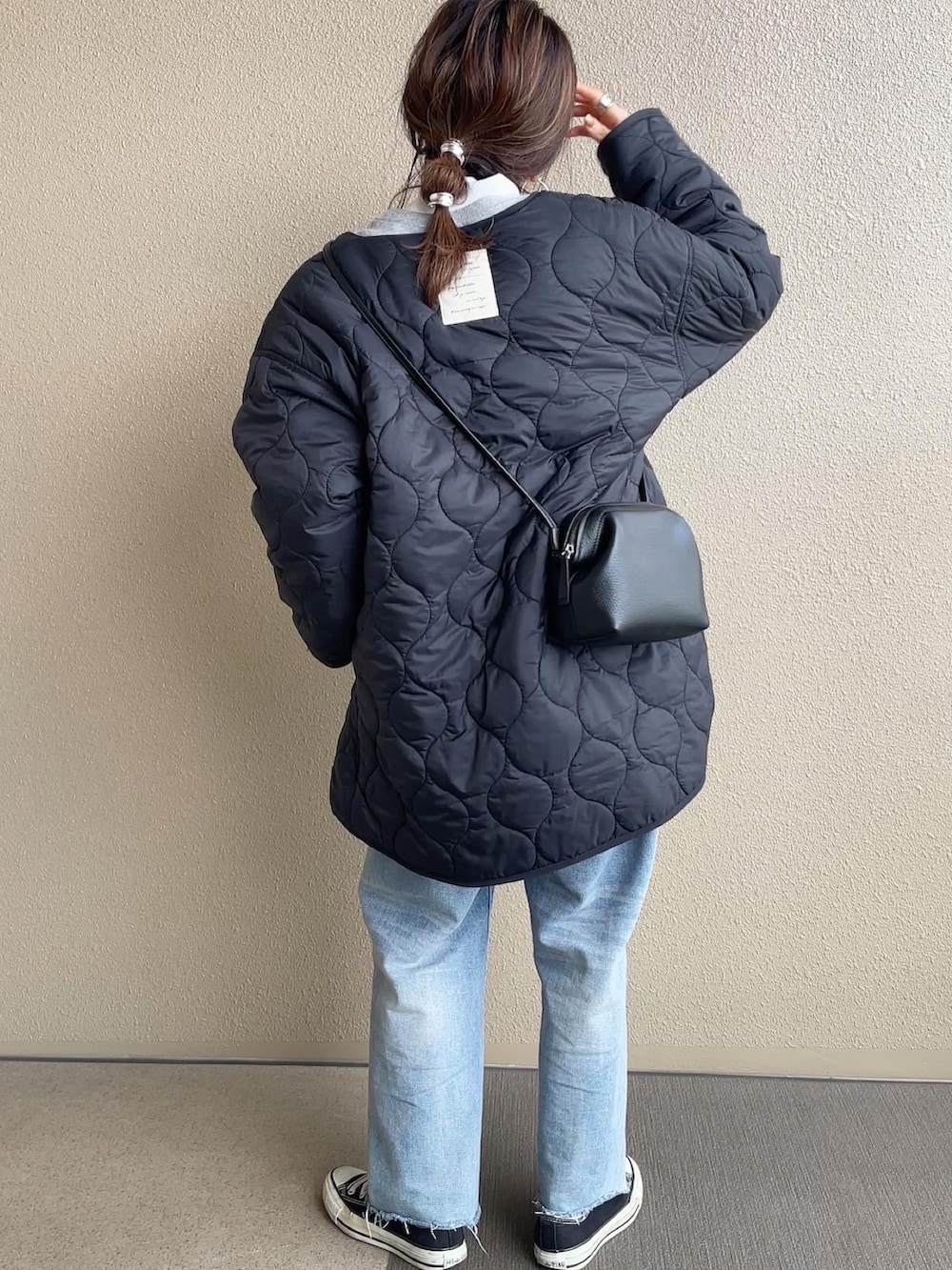 ブラック系のブルゾン、グレー系のスウェット、ブルー系のデニムパンツを着用したレディースの冬コーディネートの2枚目の写真