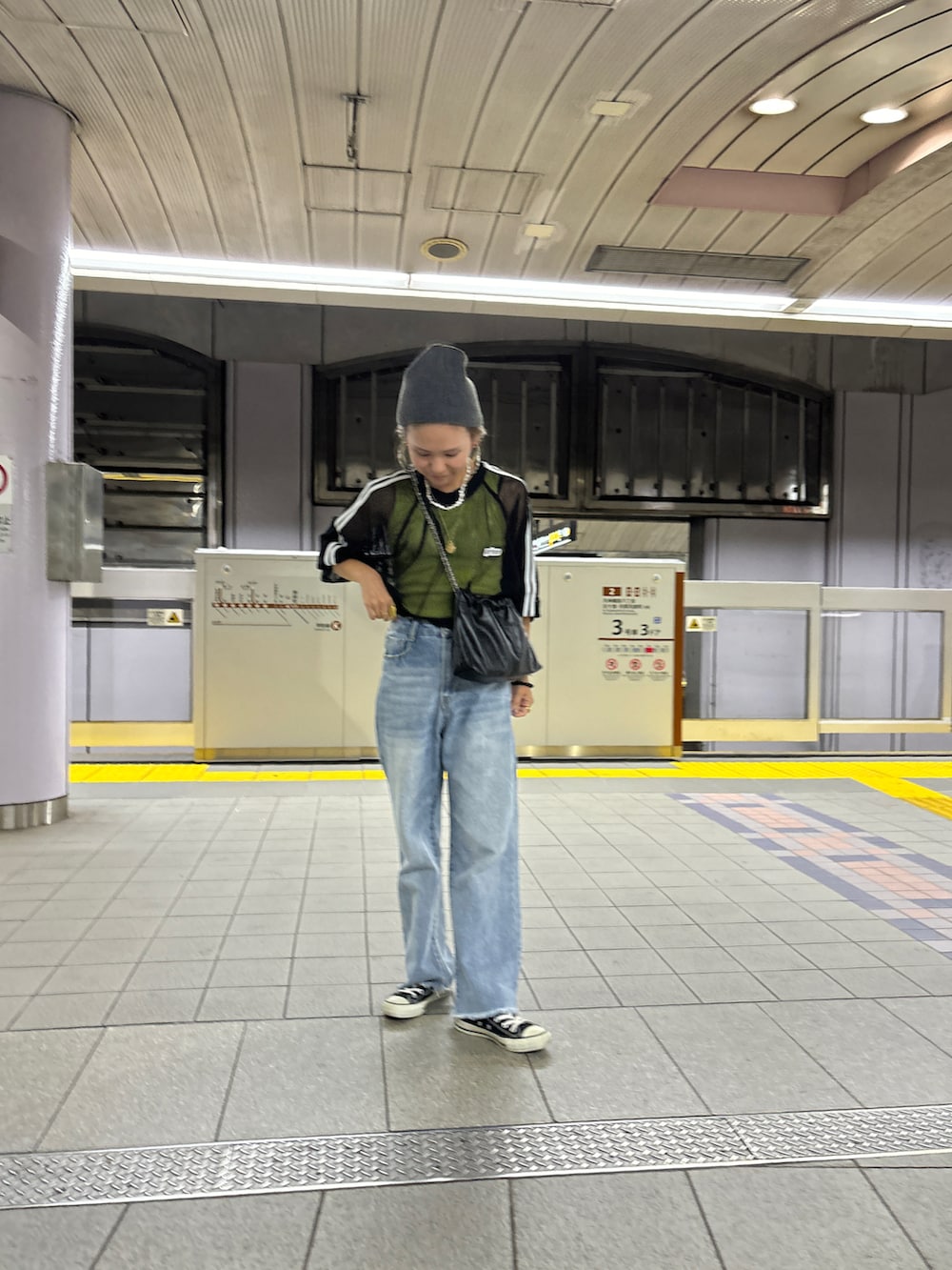 ブルー系のデニムパンツ、ブラック系のTシャツ/カットソー、グレー系のニットキャップ/ビーニーを着用したレディースの秋コーディネートの2枚目の写真