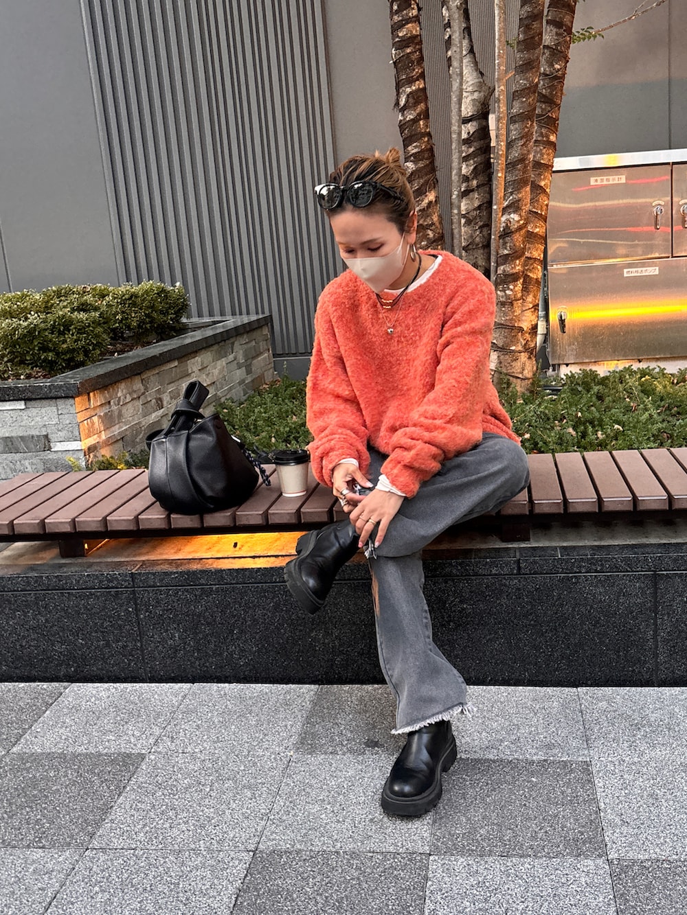 オレンジ系のニット/セーター、ブラック系のデニムパンツを着用したレディースの冬コーディネートの3枚目の写真