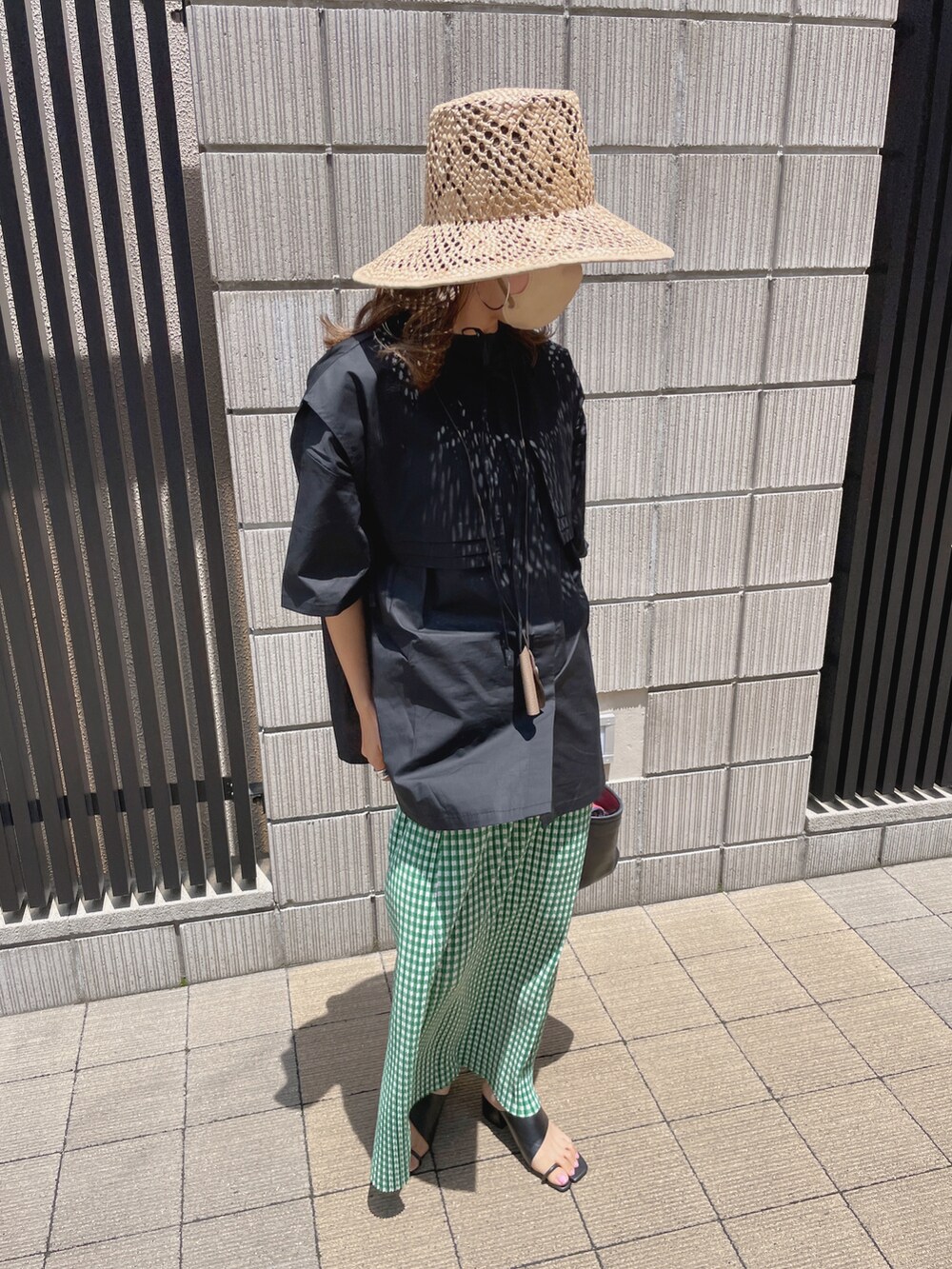 ブラック系のシャツ/ブラウス、グリーン系のスカート、ベージュ系のハットを着用したレディースの夏コーディネートの3枚目の写真