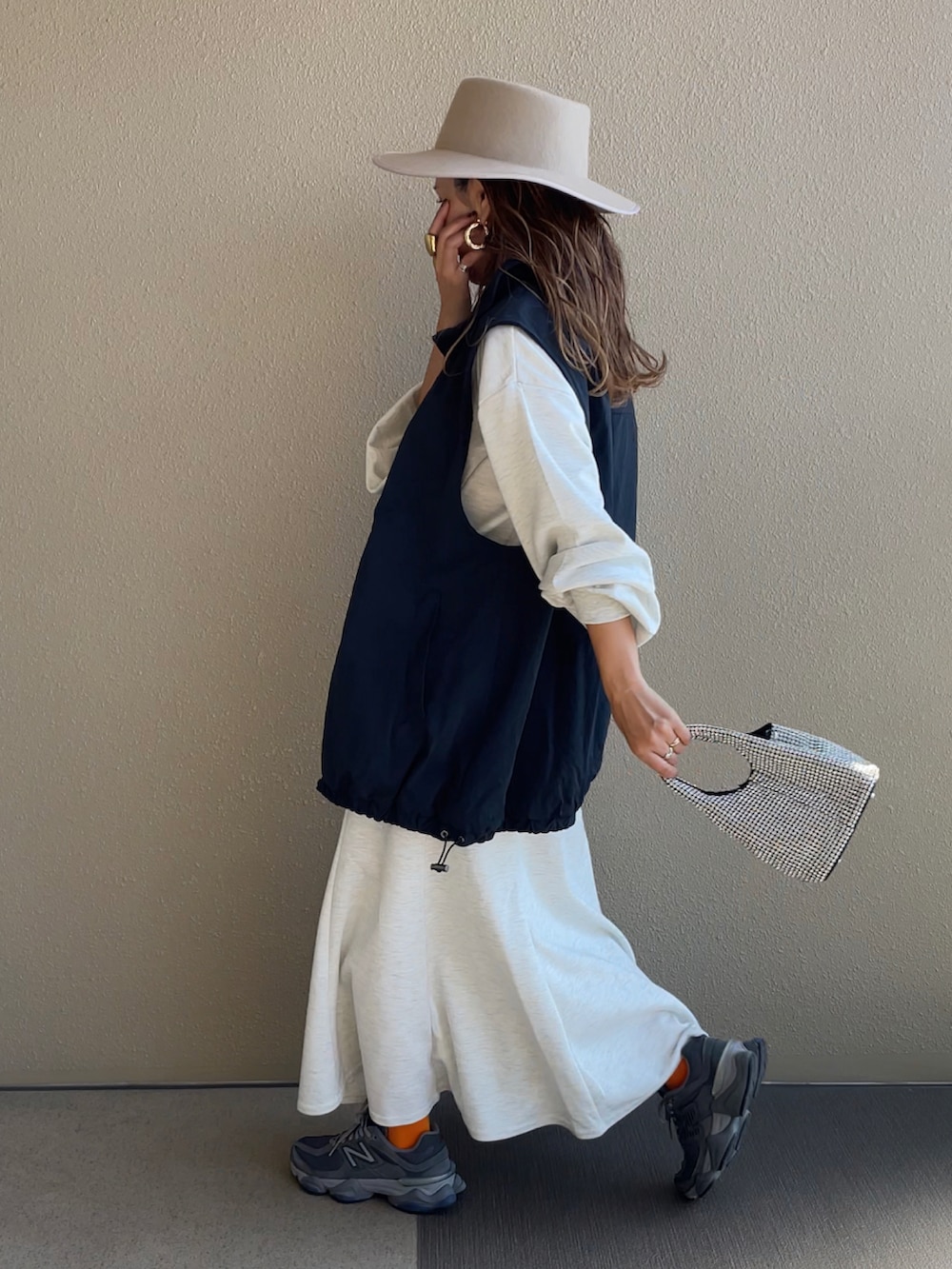 グレー系のワンピース、ブラック系のベストを着用したレディースの秋コーディネートの3枚目の写真