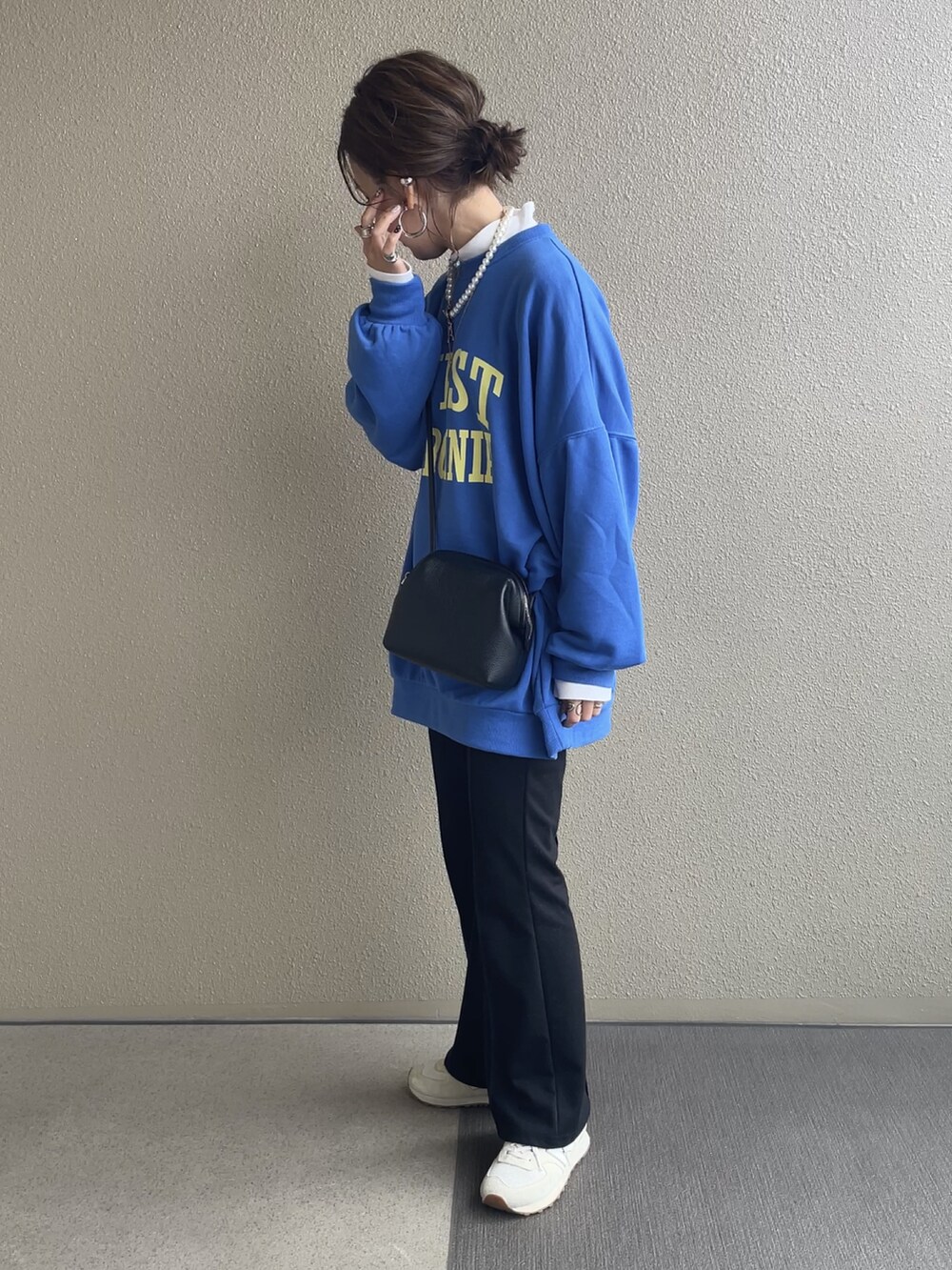 ブルー系のスウェット、ホワイト系のベスト、ブラック系のその他パンツを着用したレディースの冬コーディネートの2枚目の写真