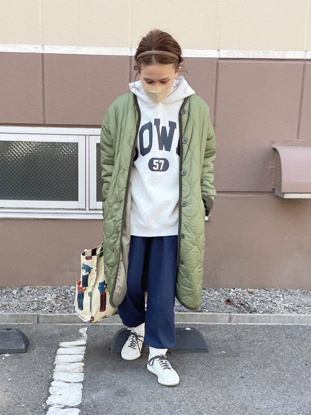 ブルー系のスウェットパンツ、ベージュ系のパーカー、グリーン系のその他アウターを着用したレディースの冬コーディネートの2枚目の写真