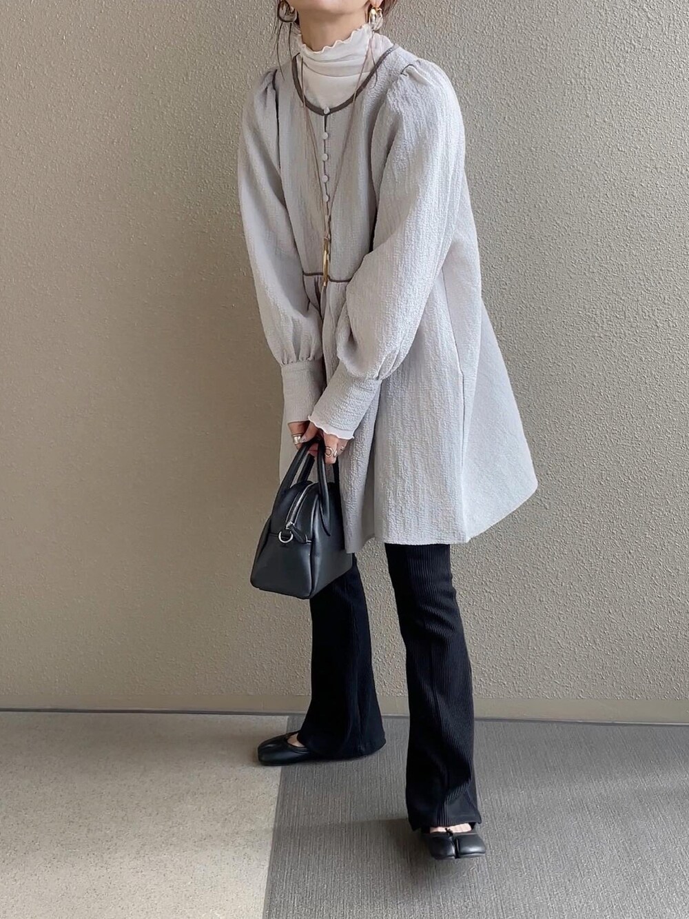 ホワイト系のベスト、グレー系のシャツ/ブラウス、ブラック系のスカートを着用したレディースの冬コーディネートの3枚目の写真